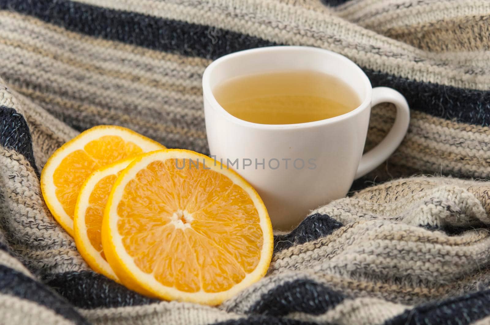 cozy autumn Breakfast with tea in white cup with honey and a warm knitted sweater  