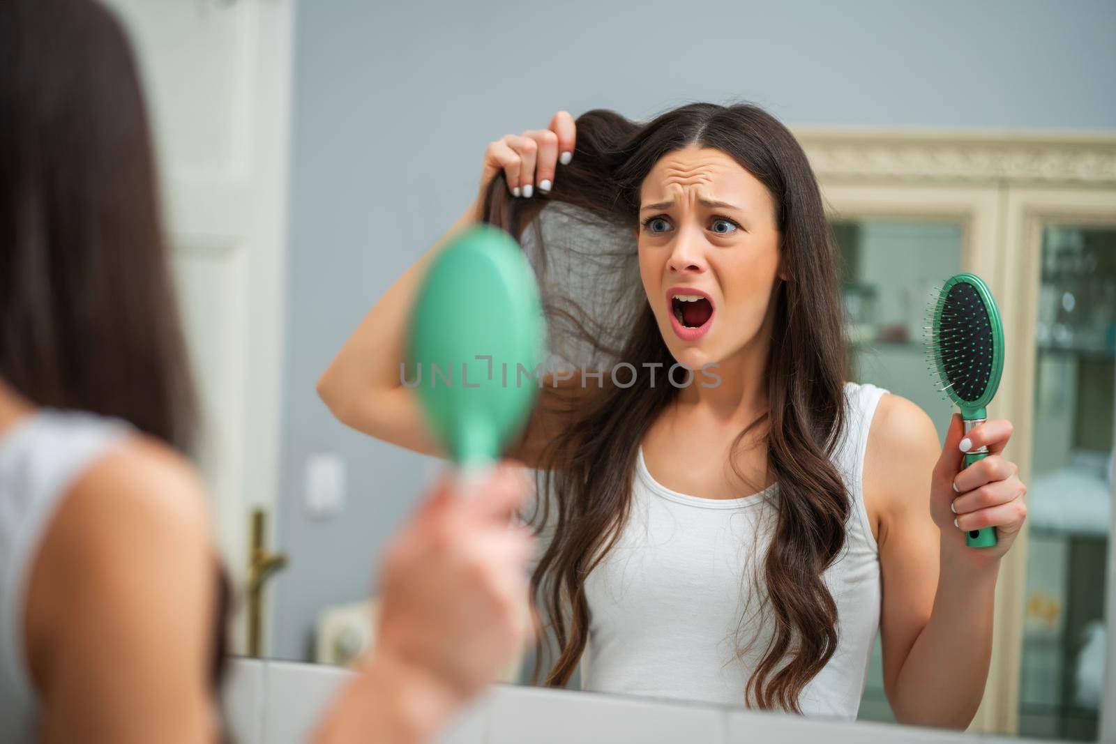 Young woman is in panic because of hair loss.