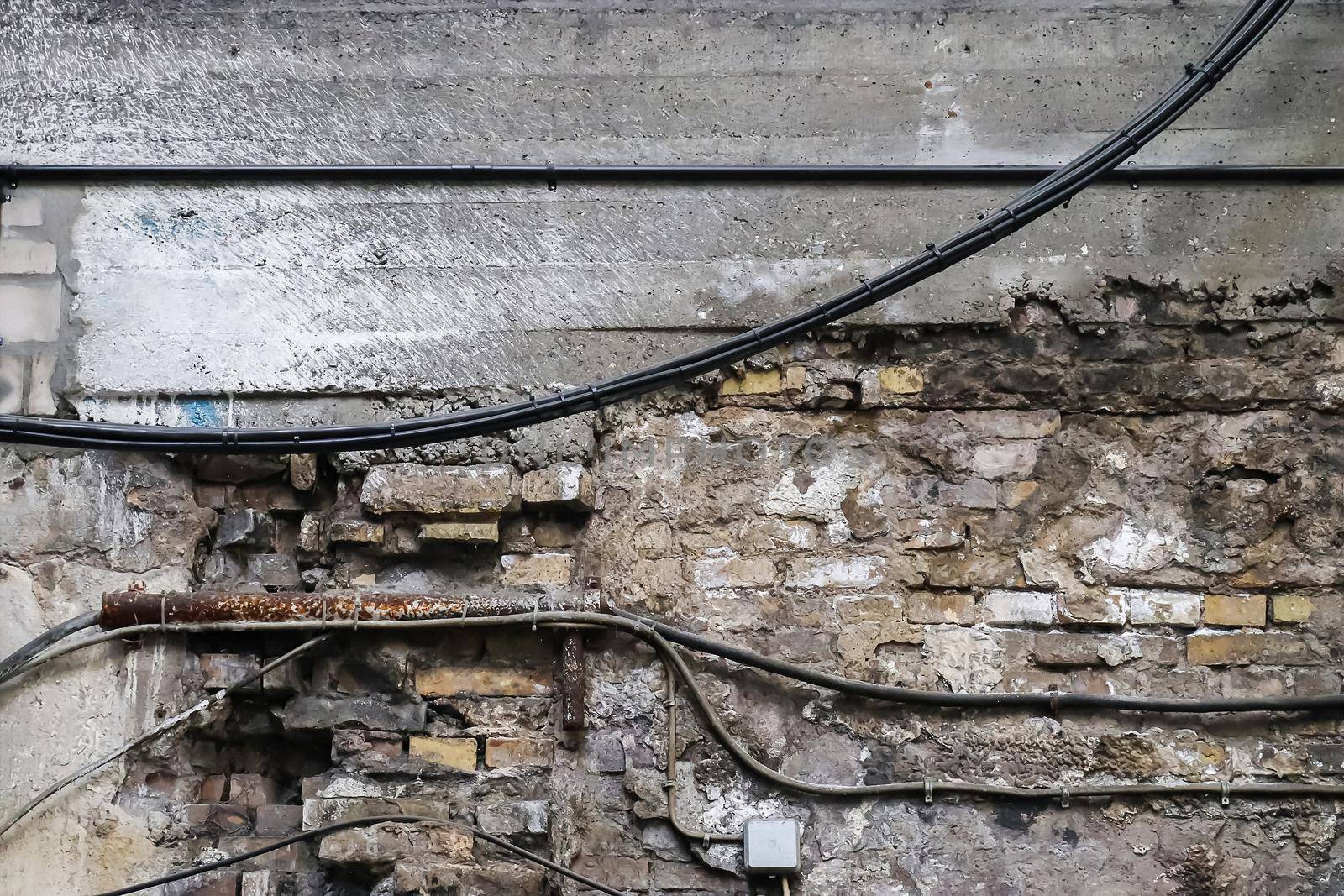 Wall in a steel mill with clear signs of use, cracks and pipes. High resolution background