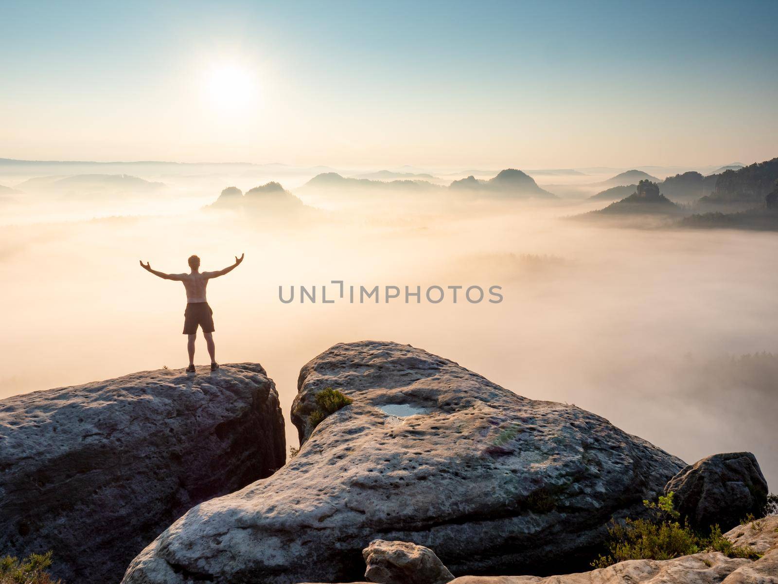 Silhouette of nature lover man with raised arms on the mountain sharp edg by rdonar2