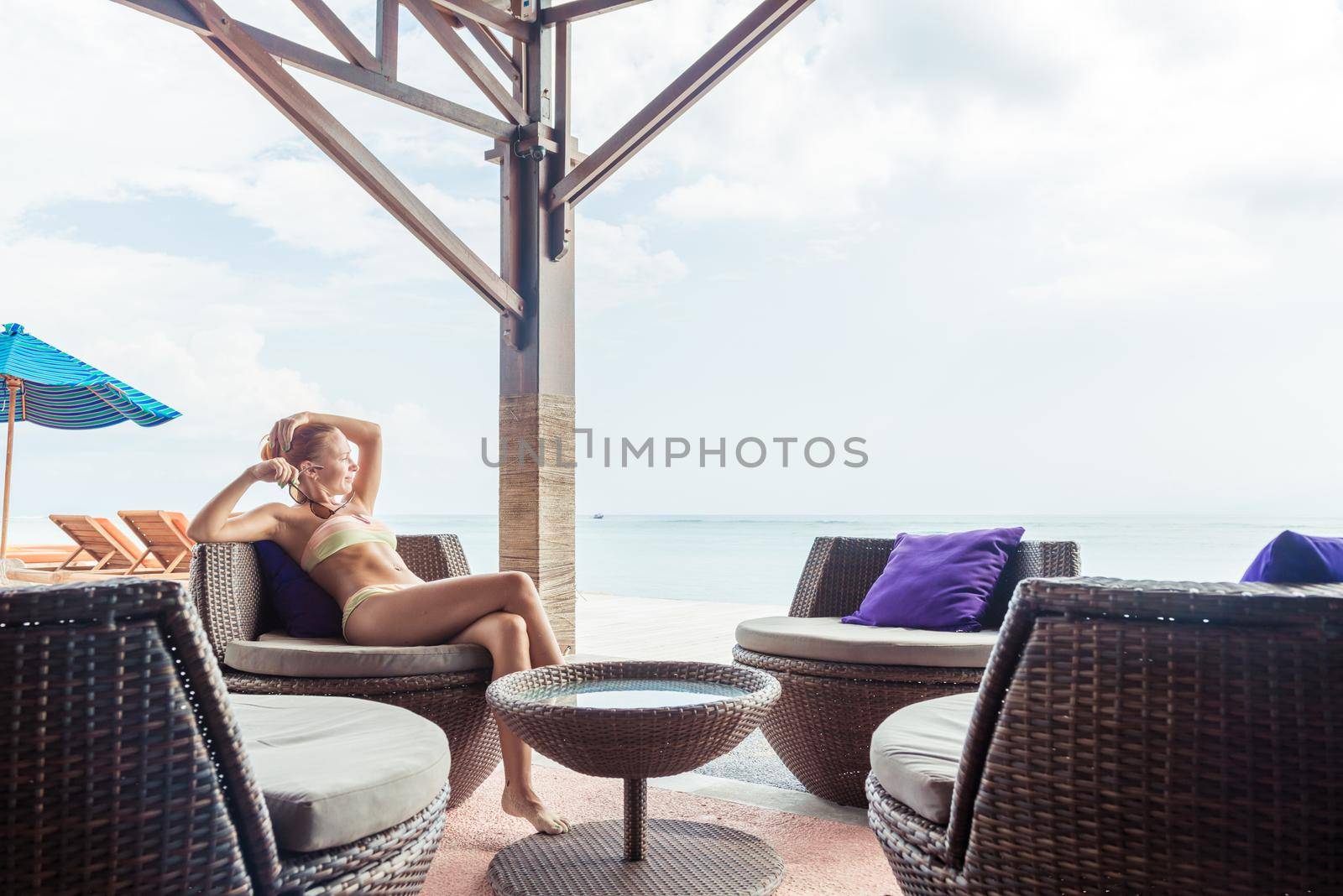 Young woman relaxing at the beach bar in Indonesia