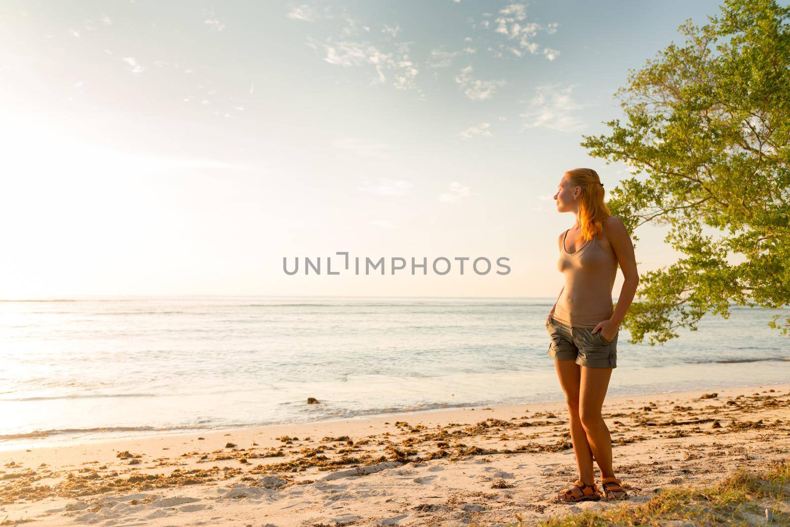 Young woman watching as sun sets over Pacific Ocean