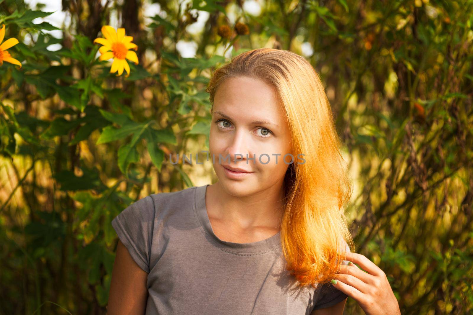 Young red-haired woman with yellow flowers outdoors