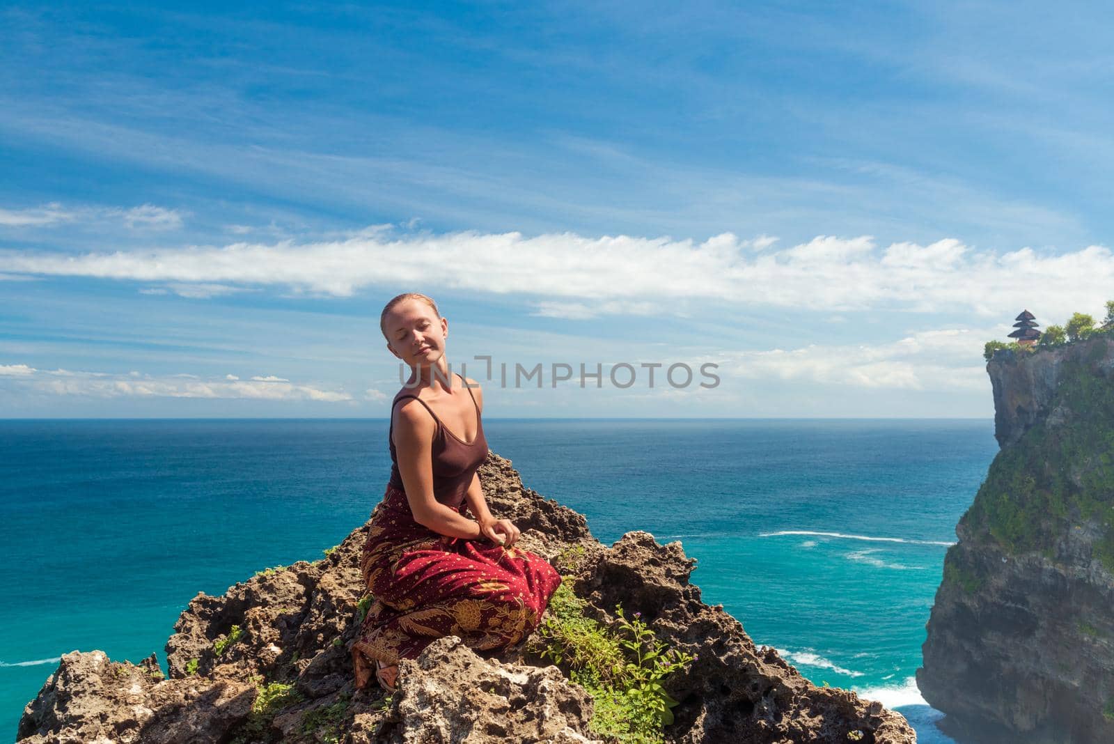 Happy young tourist posing near Uluwatu temple, Bali, Indonesia