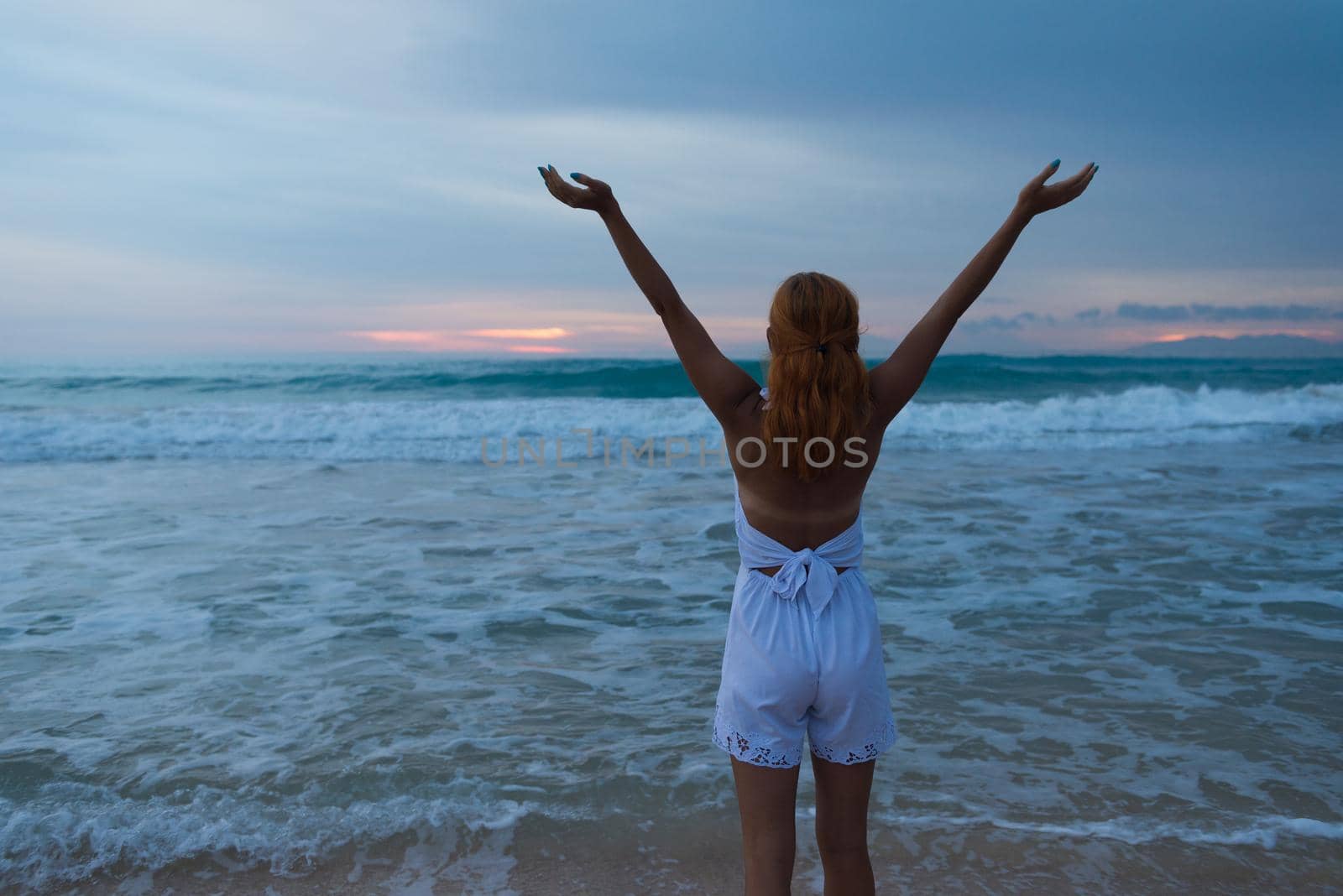 Young woman standing on ocean beach by nikitabuida