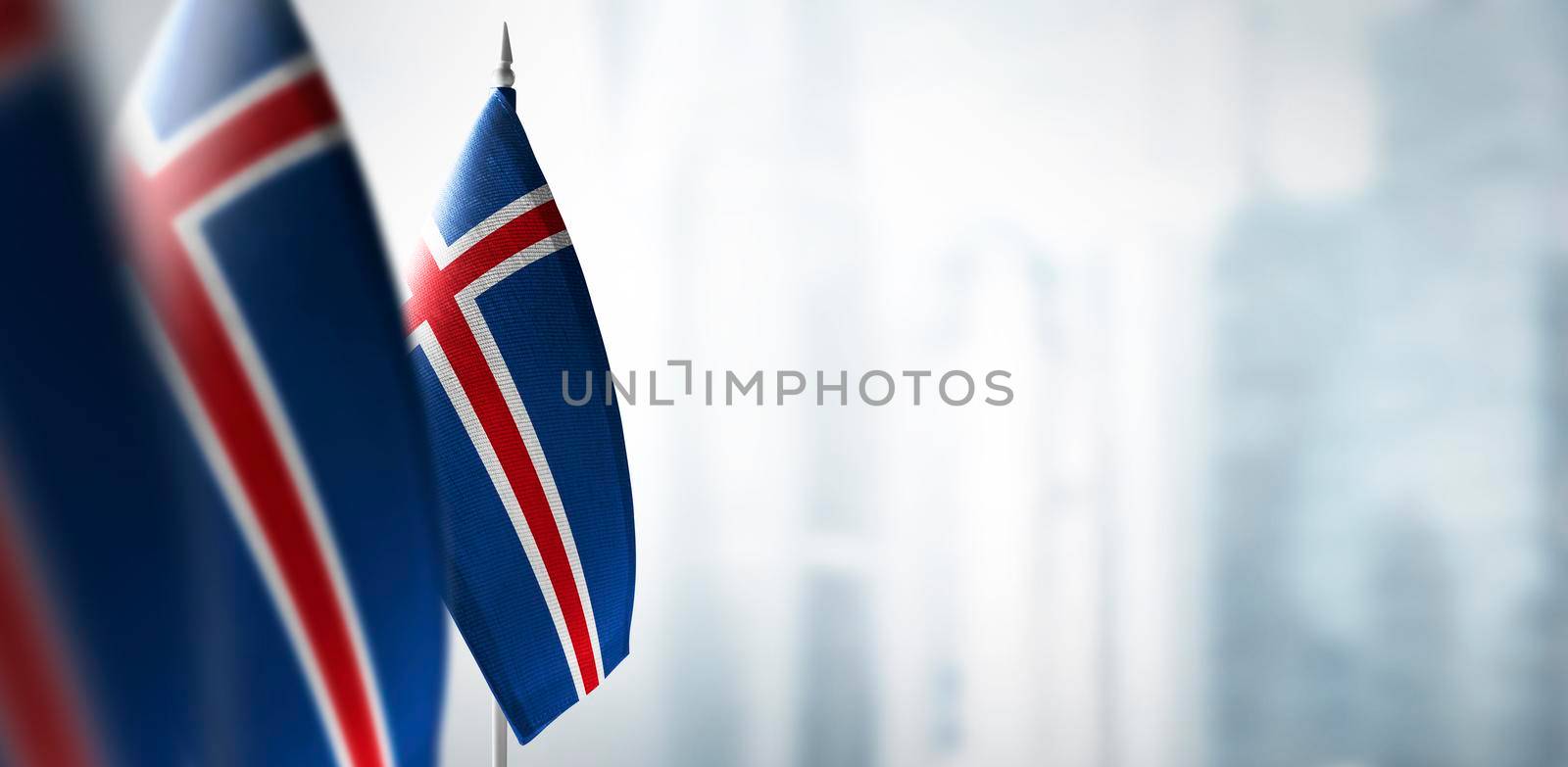 Small flags of Iceland on a blurry background of the city.