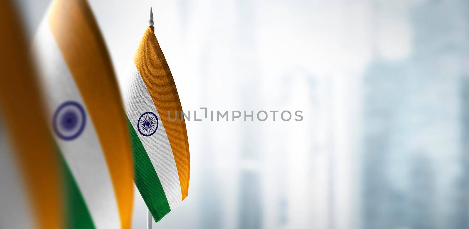 Small flags of India on a blurry background of the city by butenkow