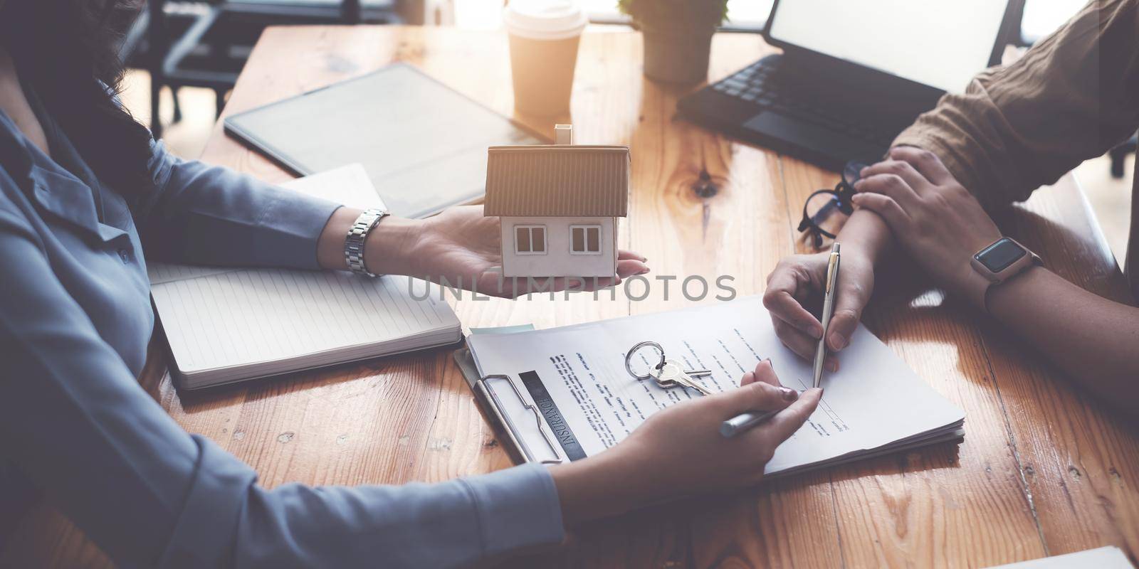 Close up of Business woman pointing and signing agreement for buying house. Bank manager and real estate concept