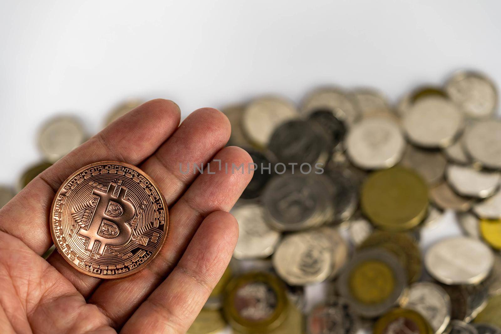 Bitcoin investment concept. Hand holding a bitcoin with blurry coins background