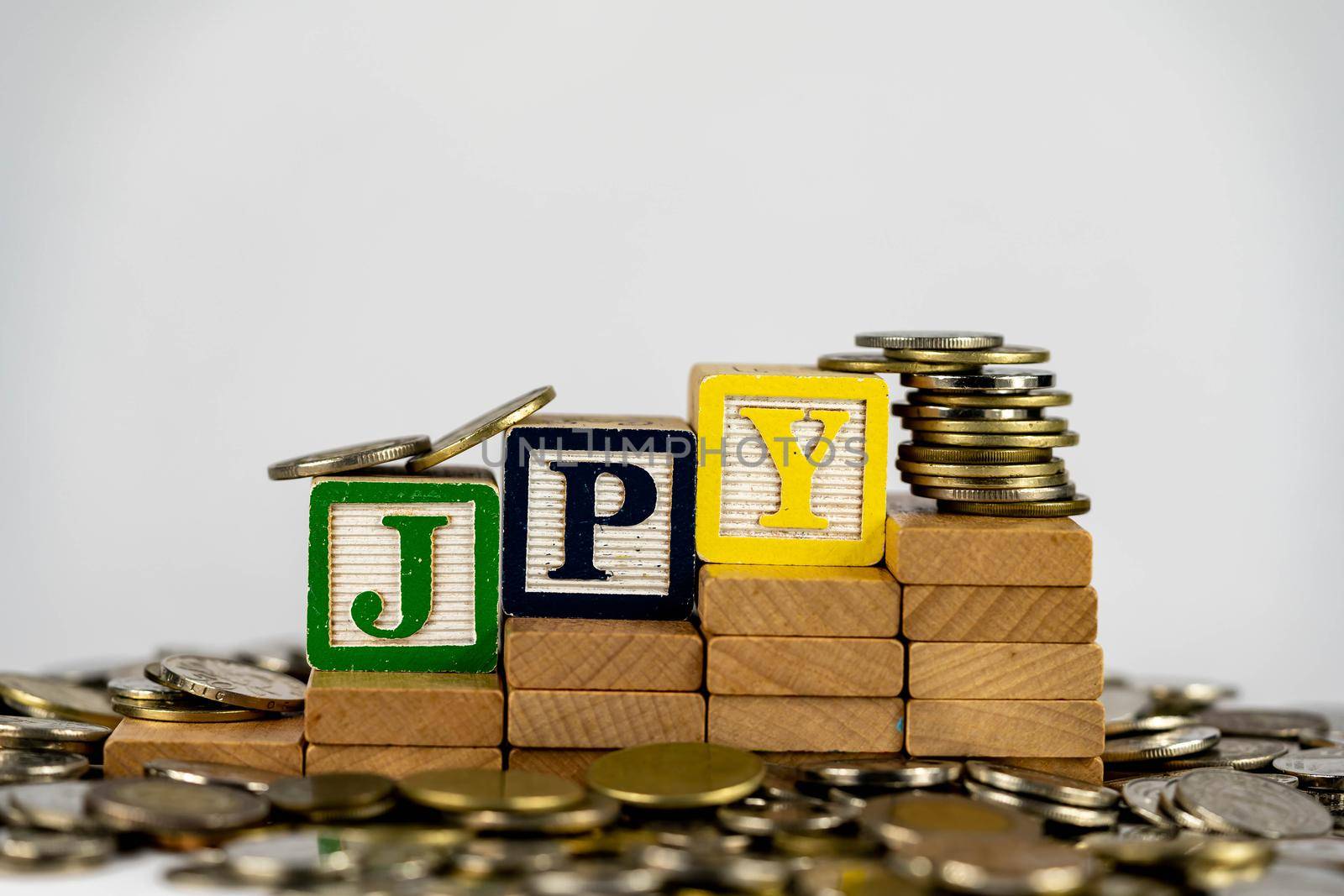 Forex JPY concept with wooden blocks and coins. Forx JPY letters on wooden blocks sorrounded with money
