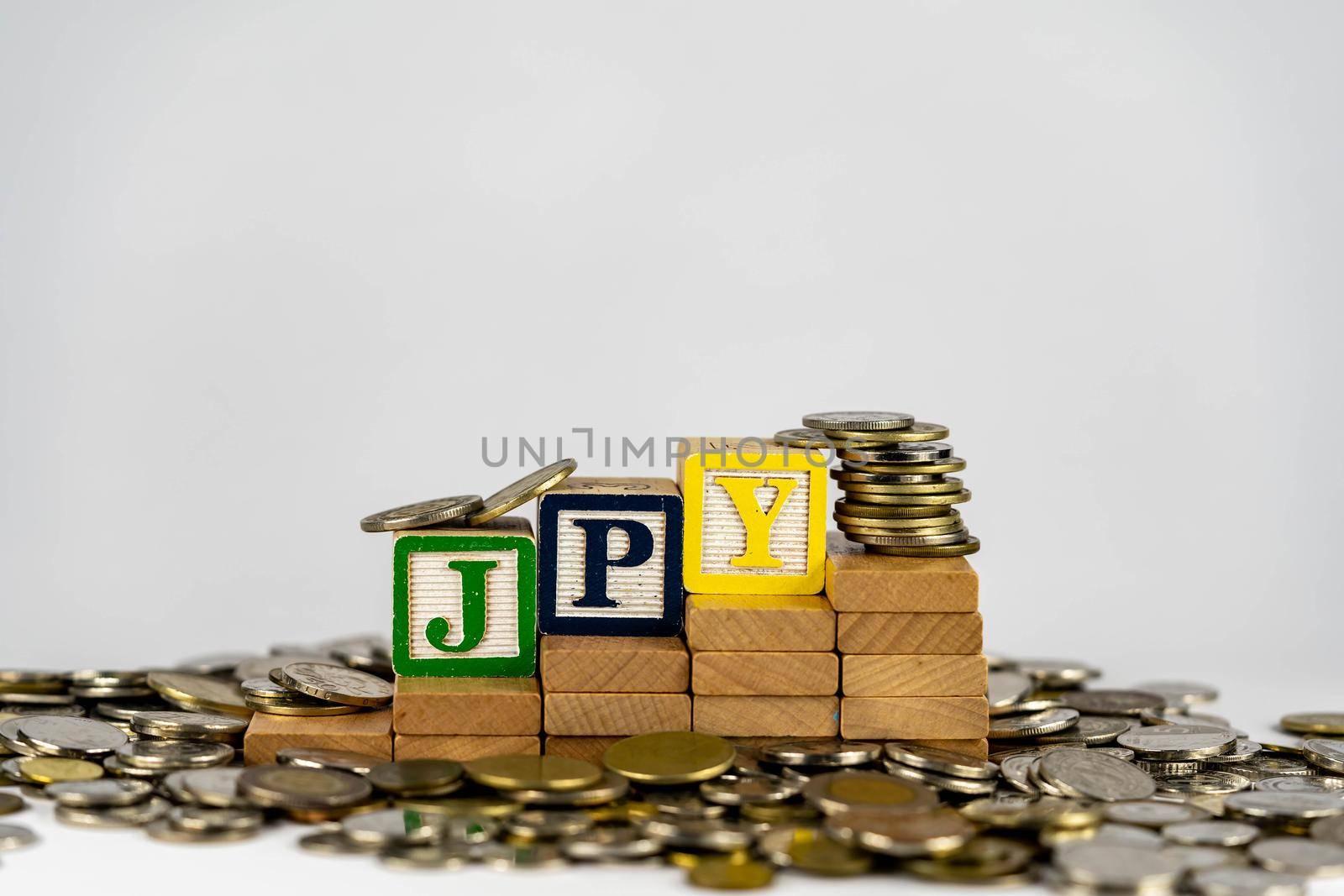 Forex JPY concept with wooden blocks and coins. Forx JPY letters on wooden blocks sorrounded with money by billroque