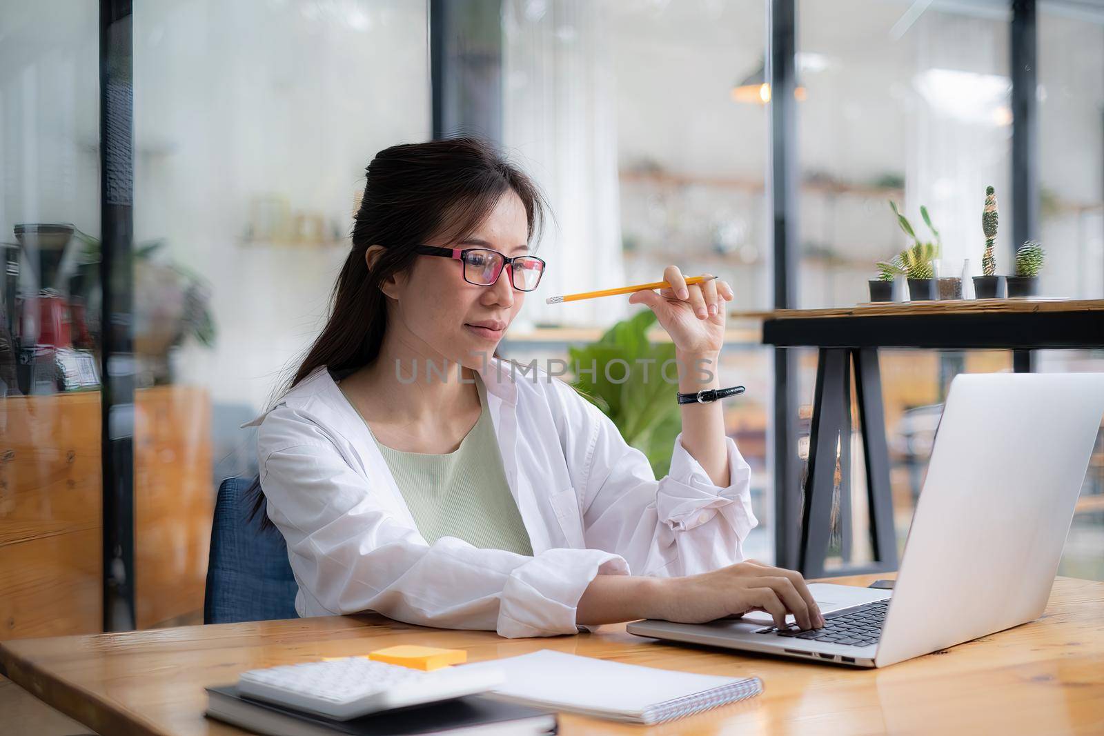 Young undergraduate student studying online class by laptop computer