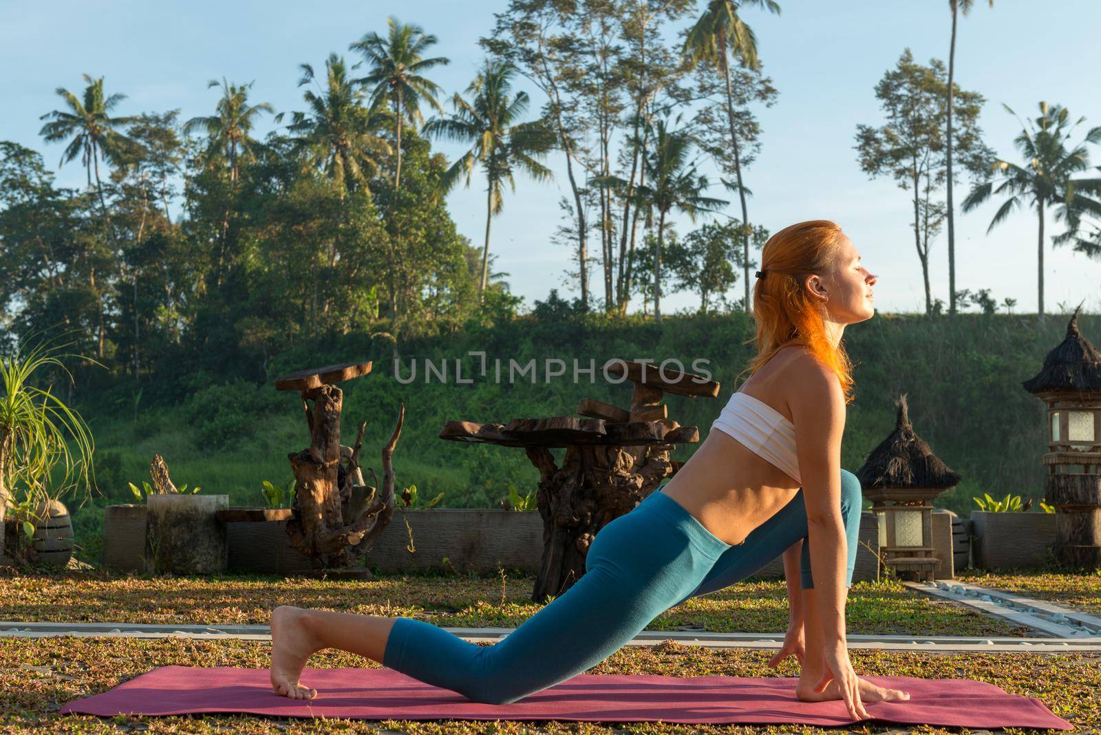 Young woman practicing yoga - greeting the sun at sunrise