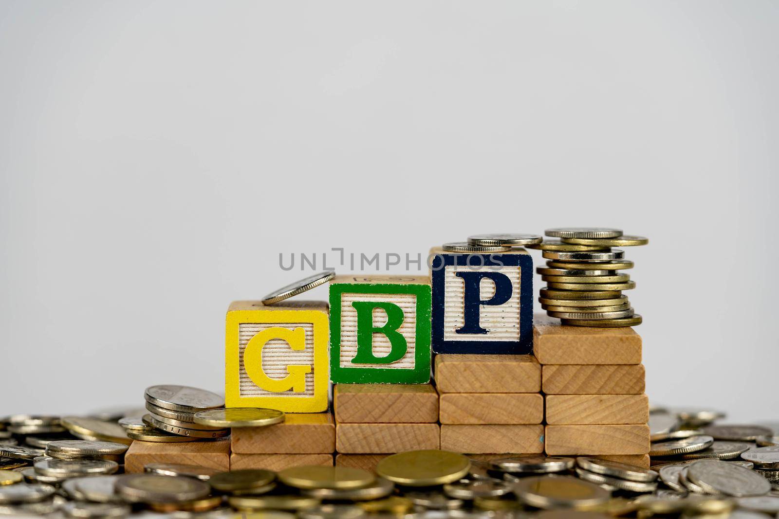 Forex GBP concept with wooden blocks and coins. Forx GBP letters on wooden blocks sorrounded with money