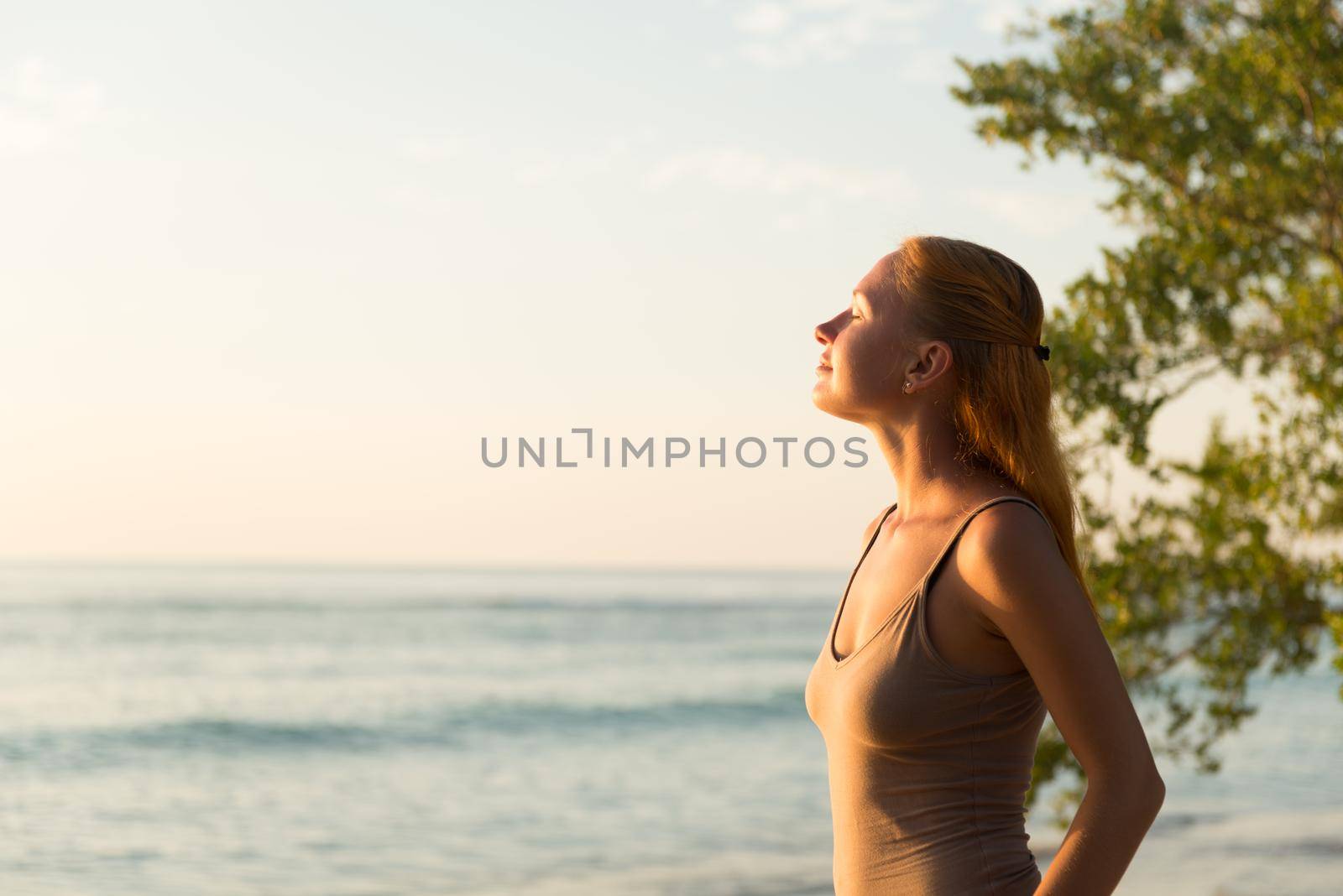 Young woman watching as sun sets over Pacific Ocean