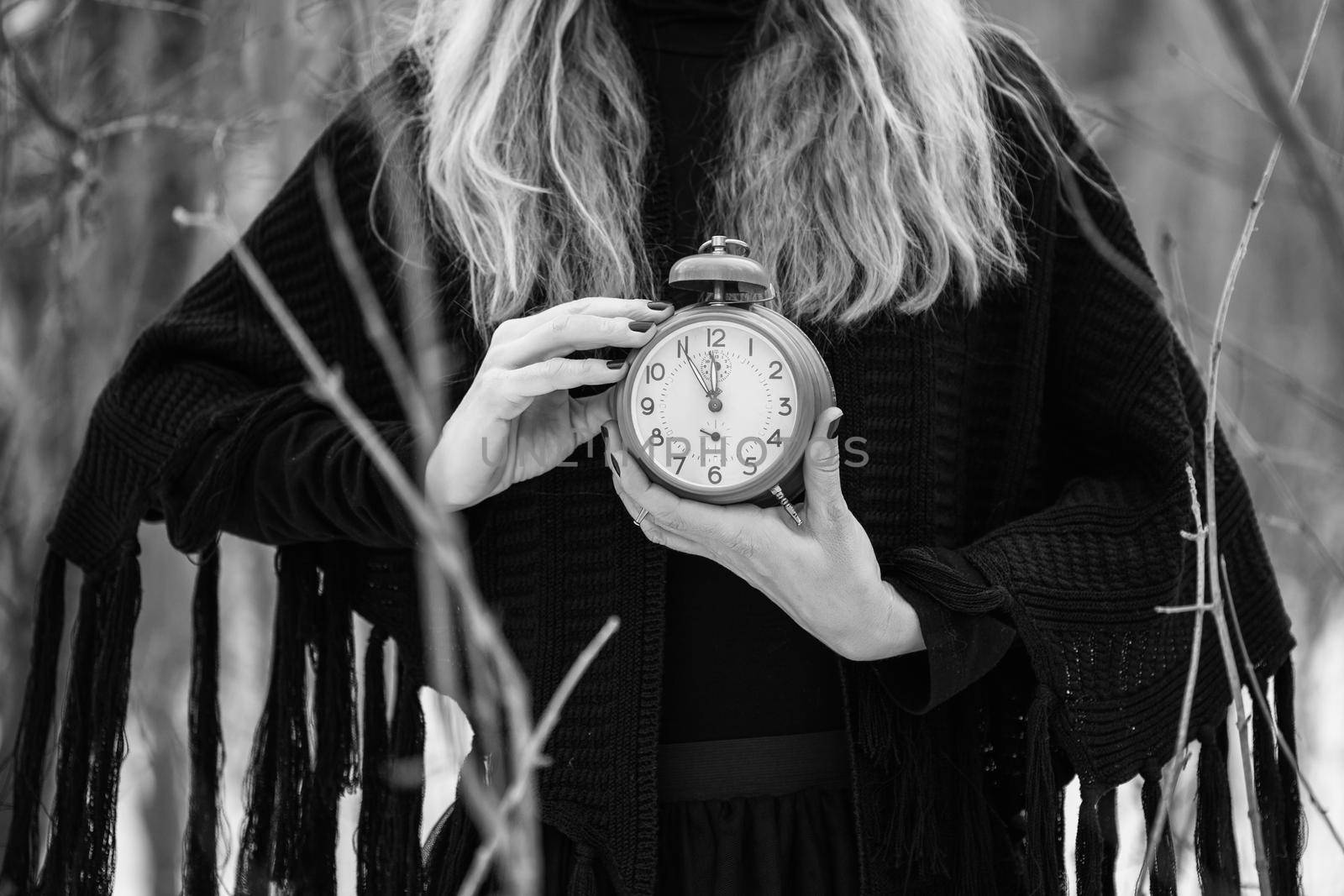 Close up image of woman holding vintage clock that shows five to twelve time.