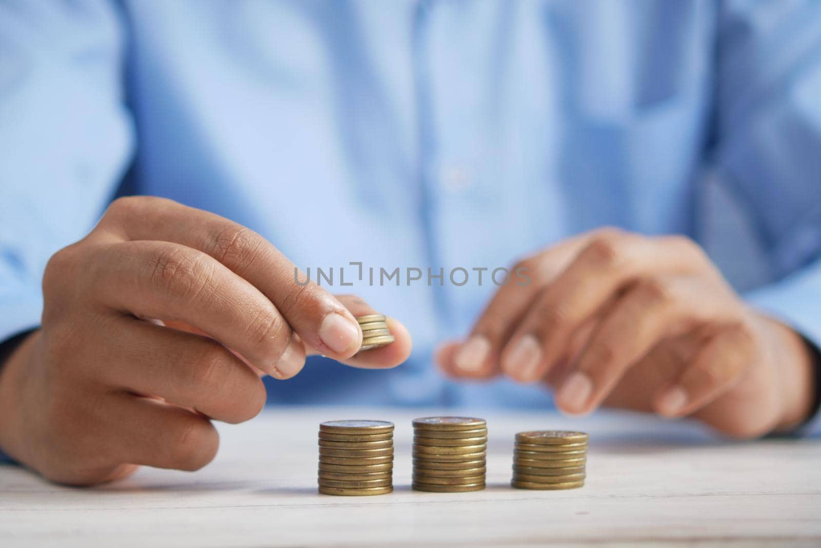 man's Hand putting stack of coins.