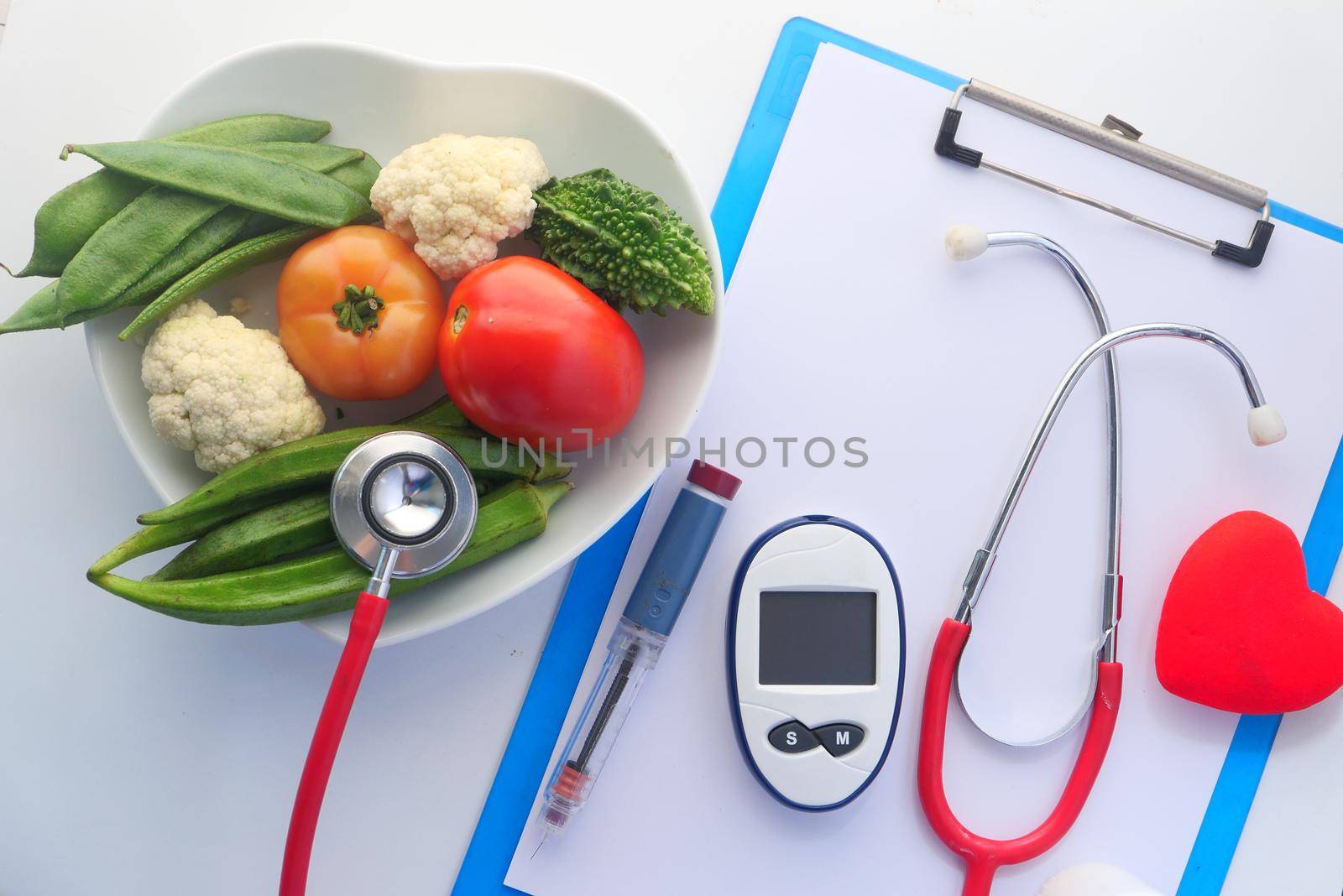 diabetic measurement tools and fresh vegetable on table .