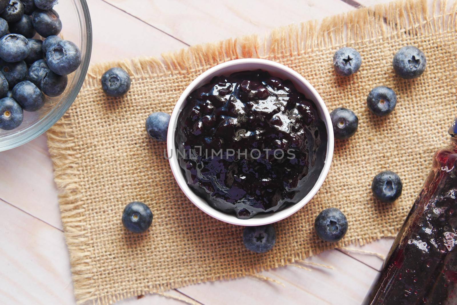 blue berry jam in container on table .