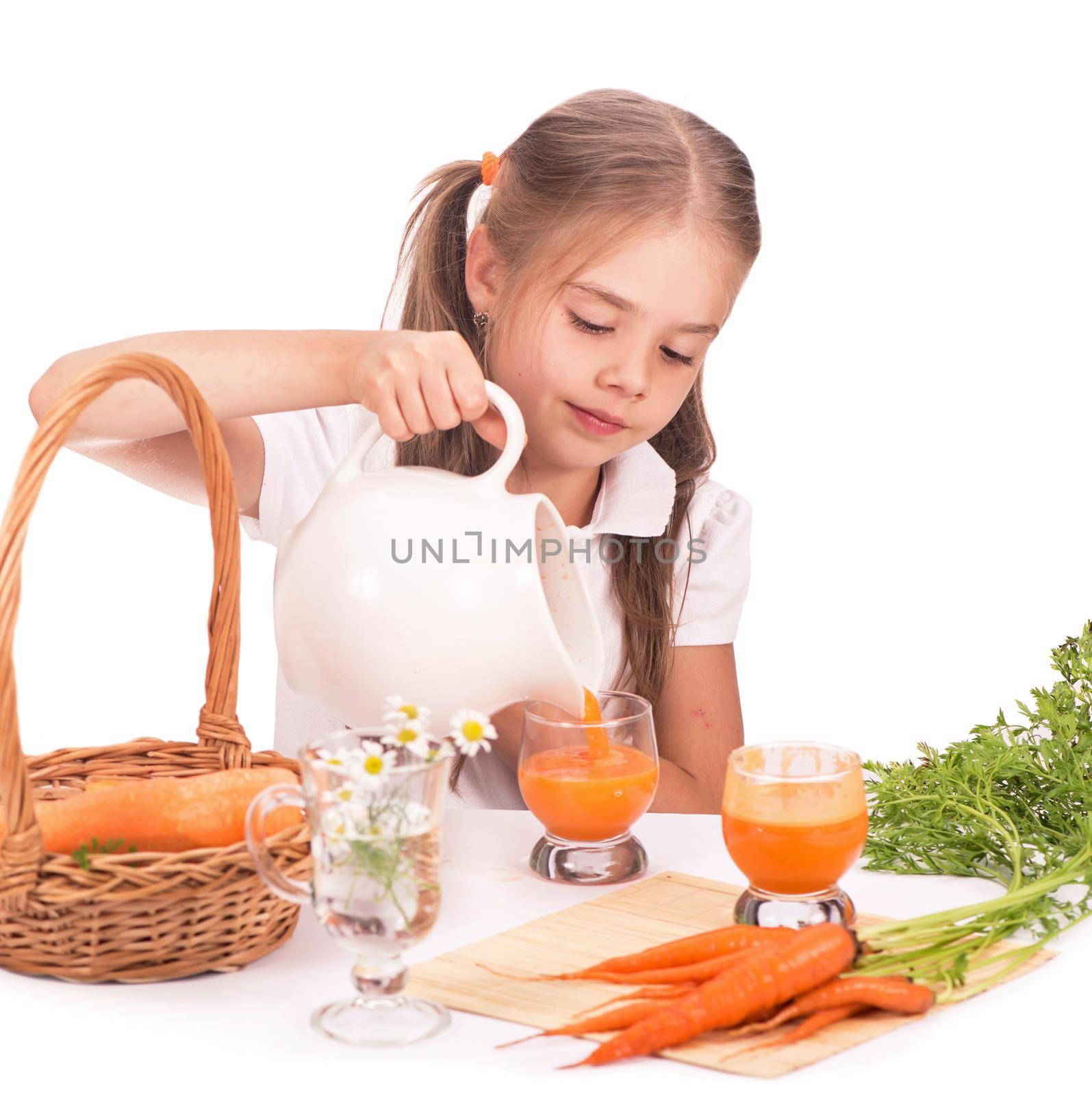 Nice blond baby girl with glass of carrot juice