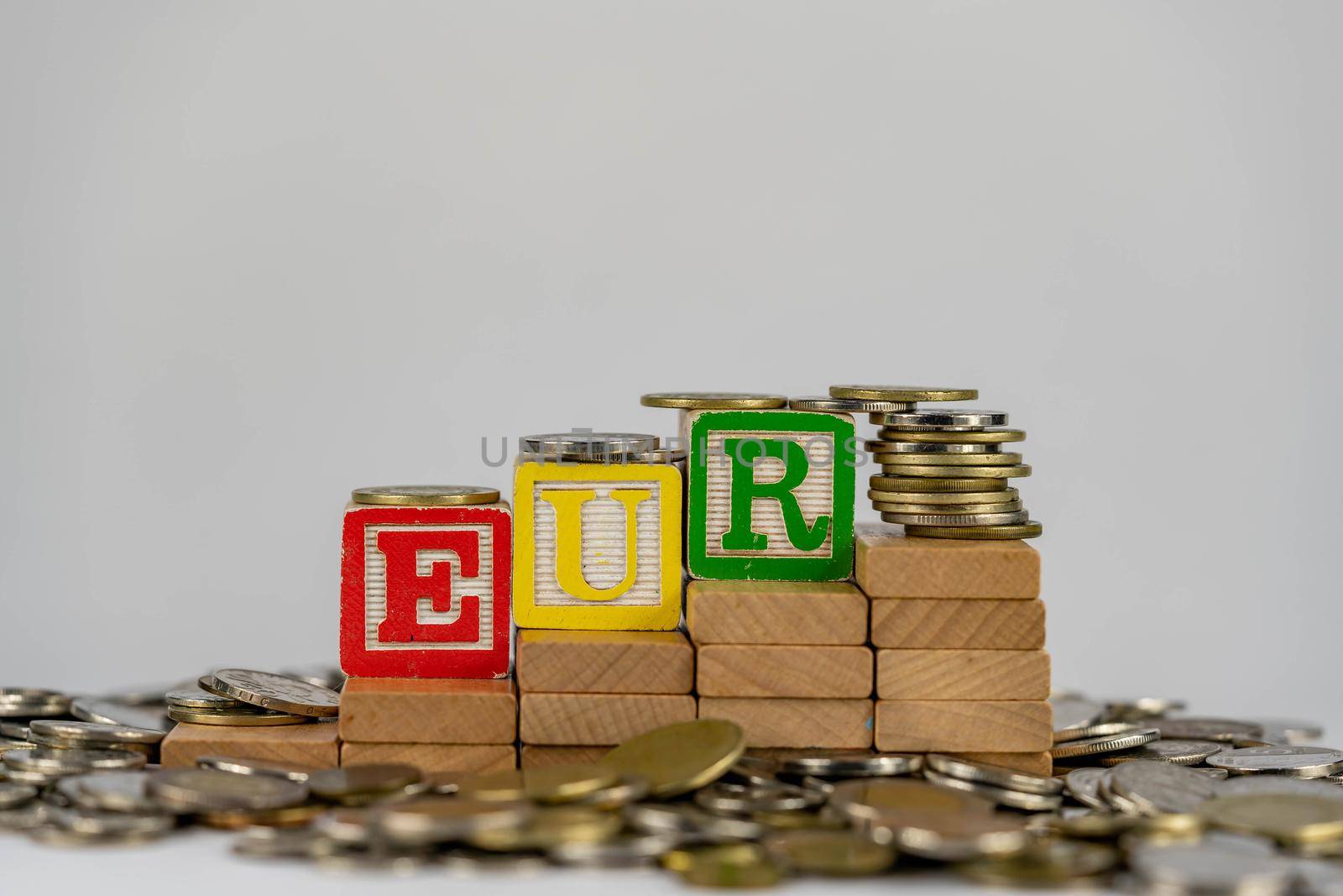 Forex EUR concept with wooden blocks and coins. Forx EUR letters on wooden blocks sorrounded with money by billroque