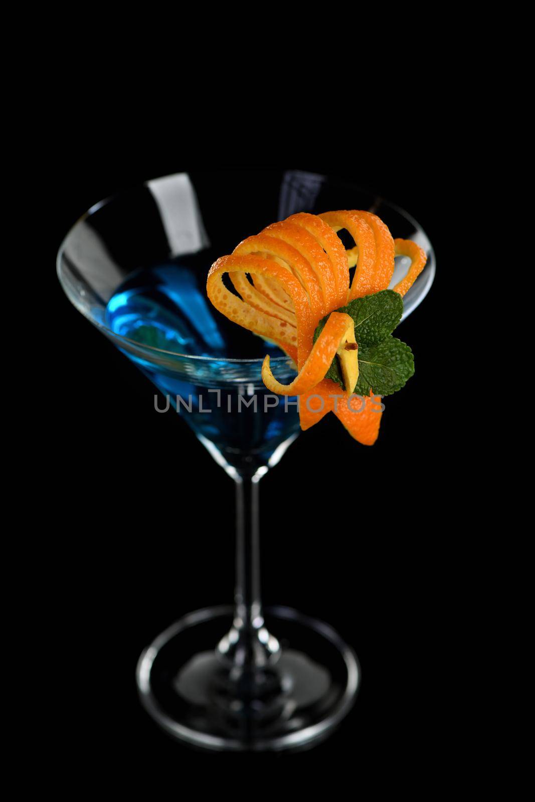 Decoration for a cocktail of orange and mint. Elegant and original presentation. Martini Blue Curacao on a black background