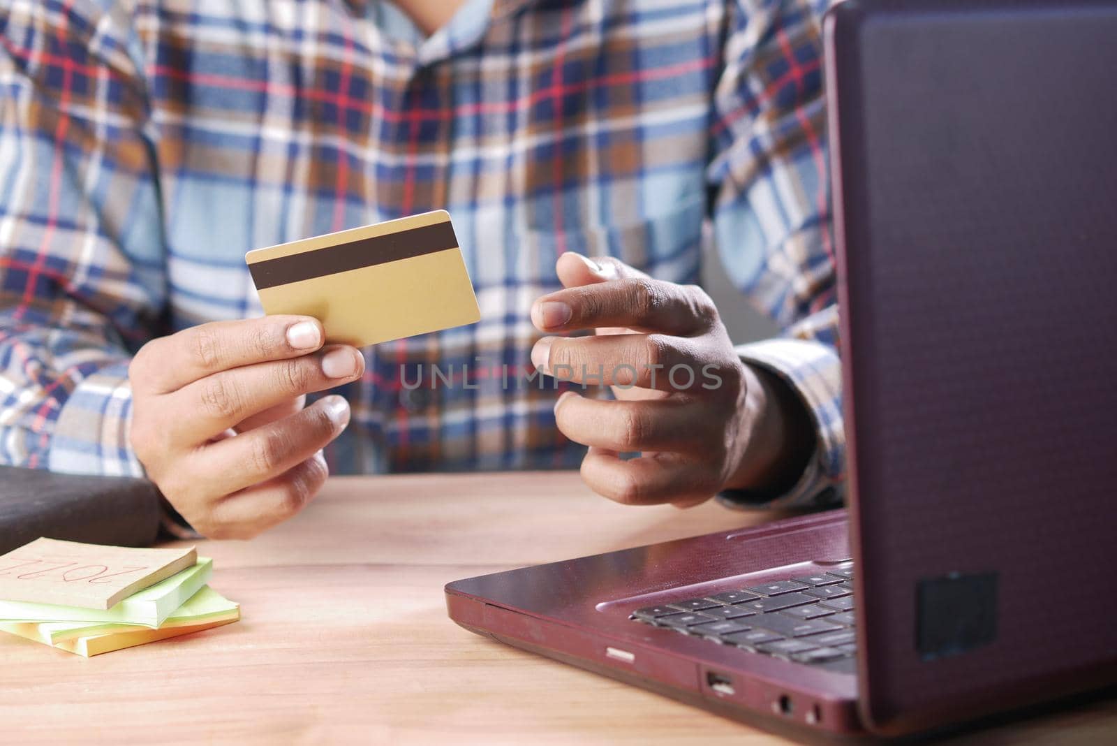 man hands holding credit card and using laptop shopping online .