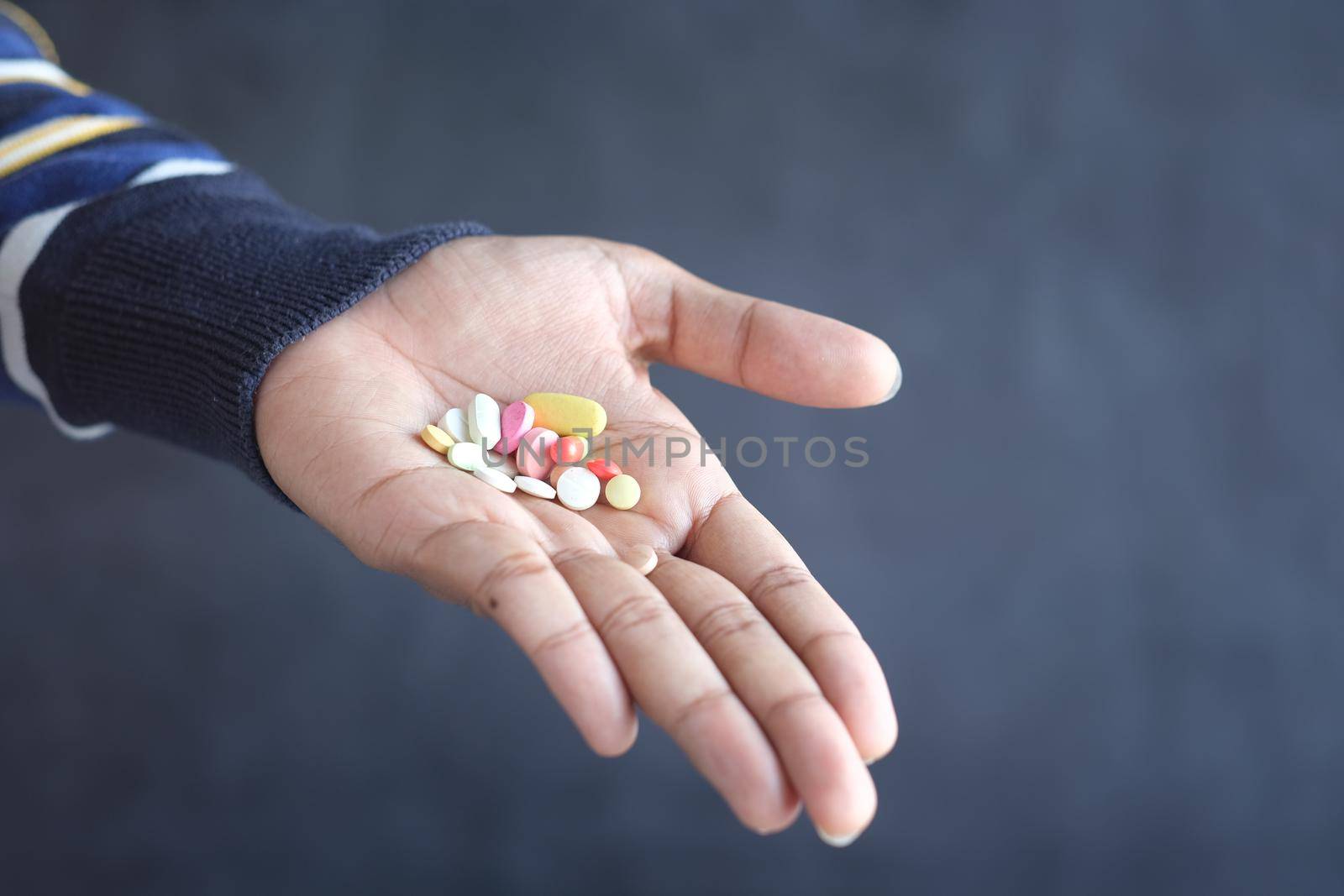 man's hand with pills spilled out of the container .