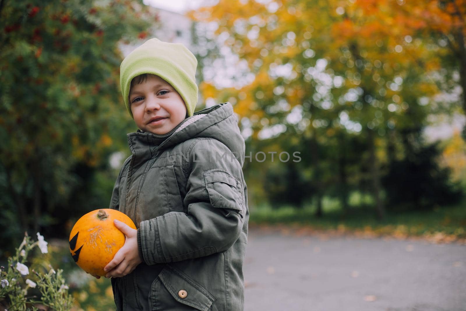 A boy with a Halloween pumpkin with eyes . The feast of fear. Halloween. An orange pumpkin with eyes. An article about Halloween.