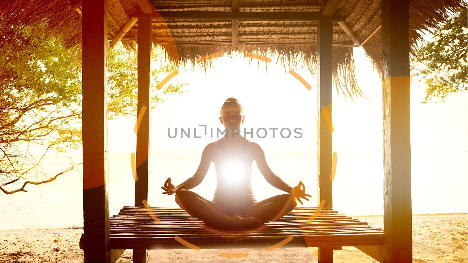 Young woman meditating in lotus pose at the ocean shore