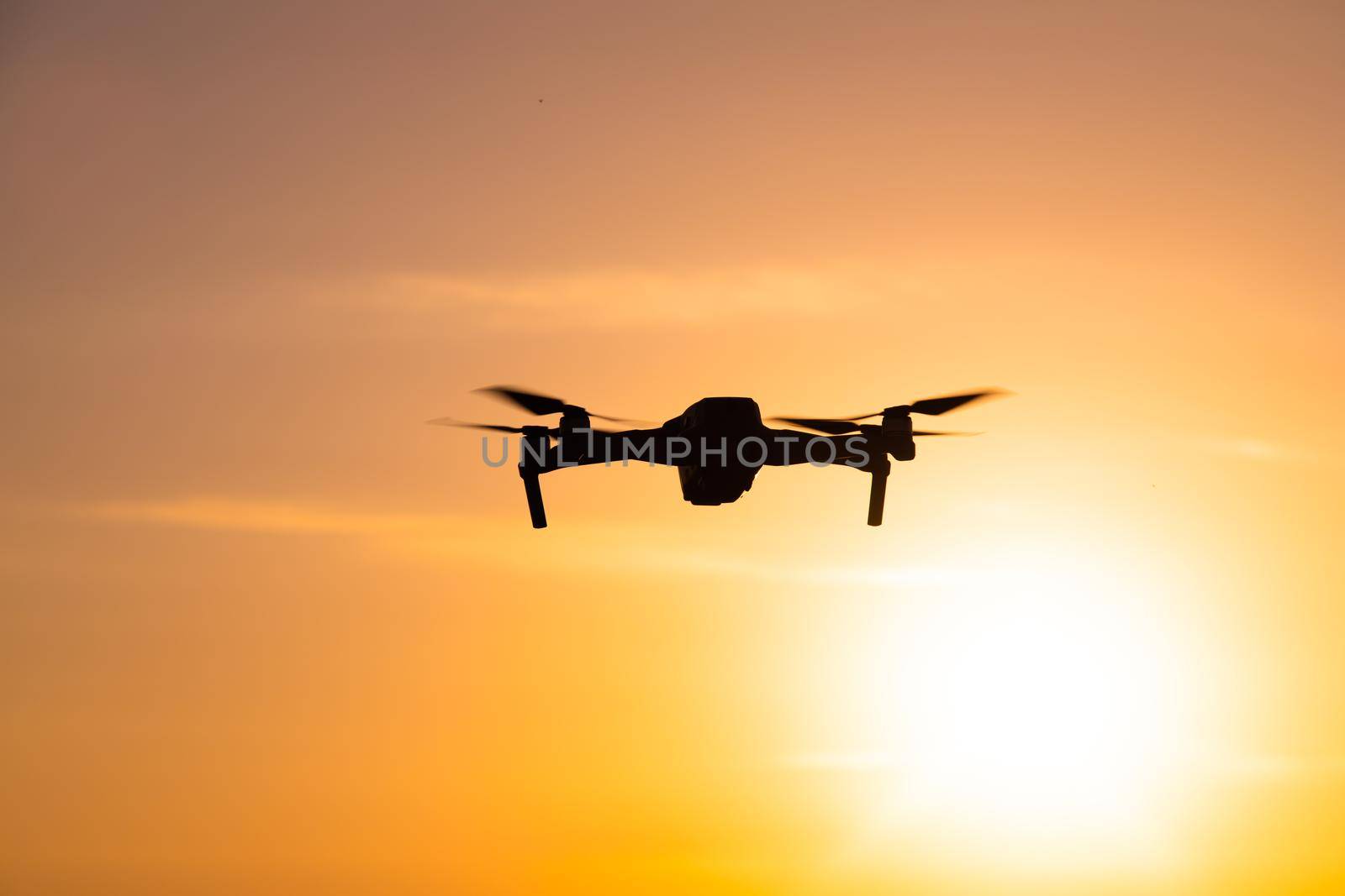 The drone is in flight at sunset . Video shooting from above. An article about the choice of a quadrocopter. Pros and cons of the drone. Sunset