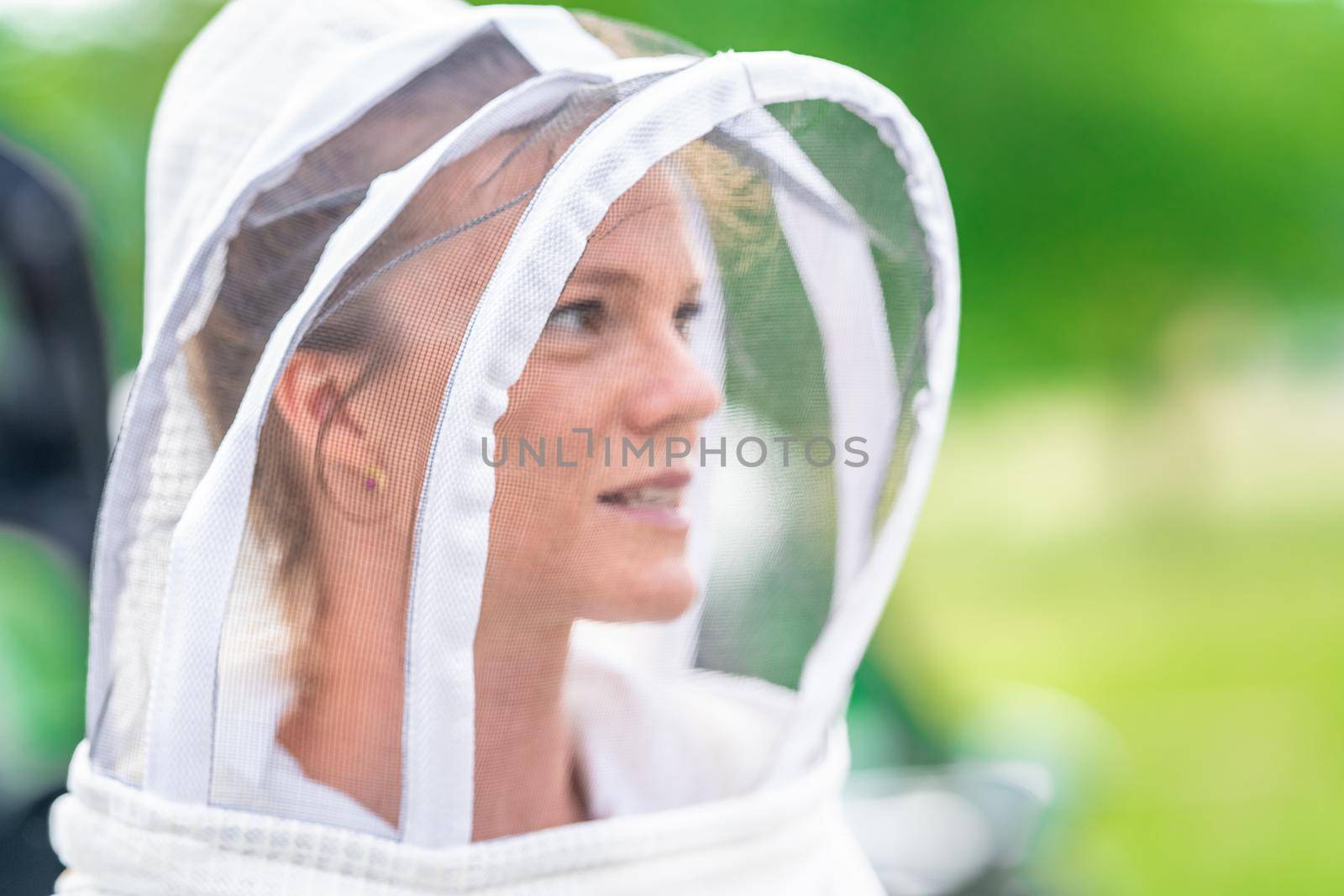woman beekeeper in protective suit in beekeeping by Edophoto