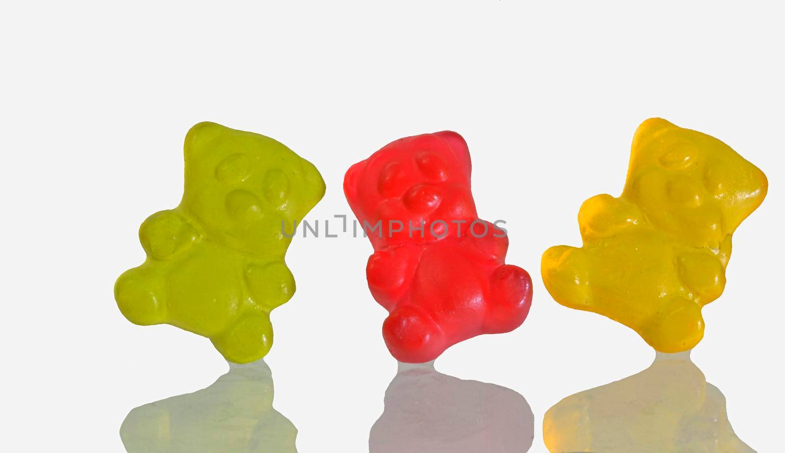 Dancing colorful jelly gummy bears, isolated on white background. Multicolored jelly bears candy isolated on a white background. Jelly Bean. Mirror reflection of jelly bears.