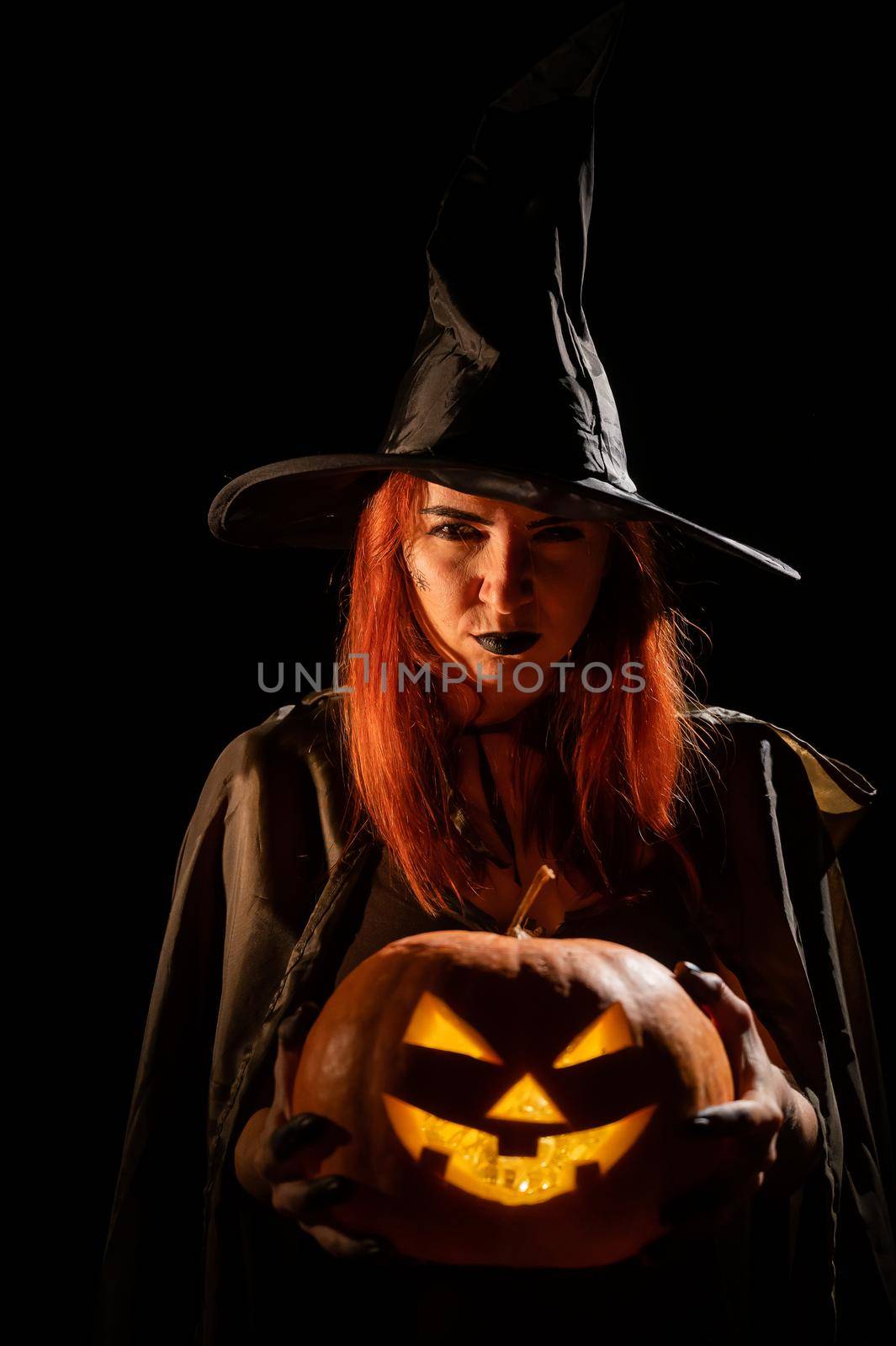 Wicked witch holding a jack-o-lantern for halloween by mrwed54