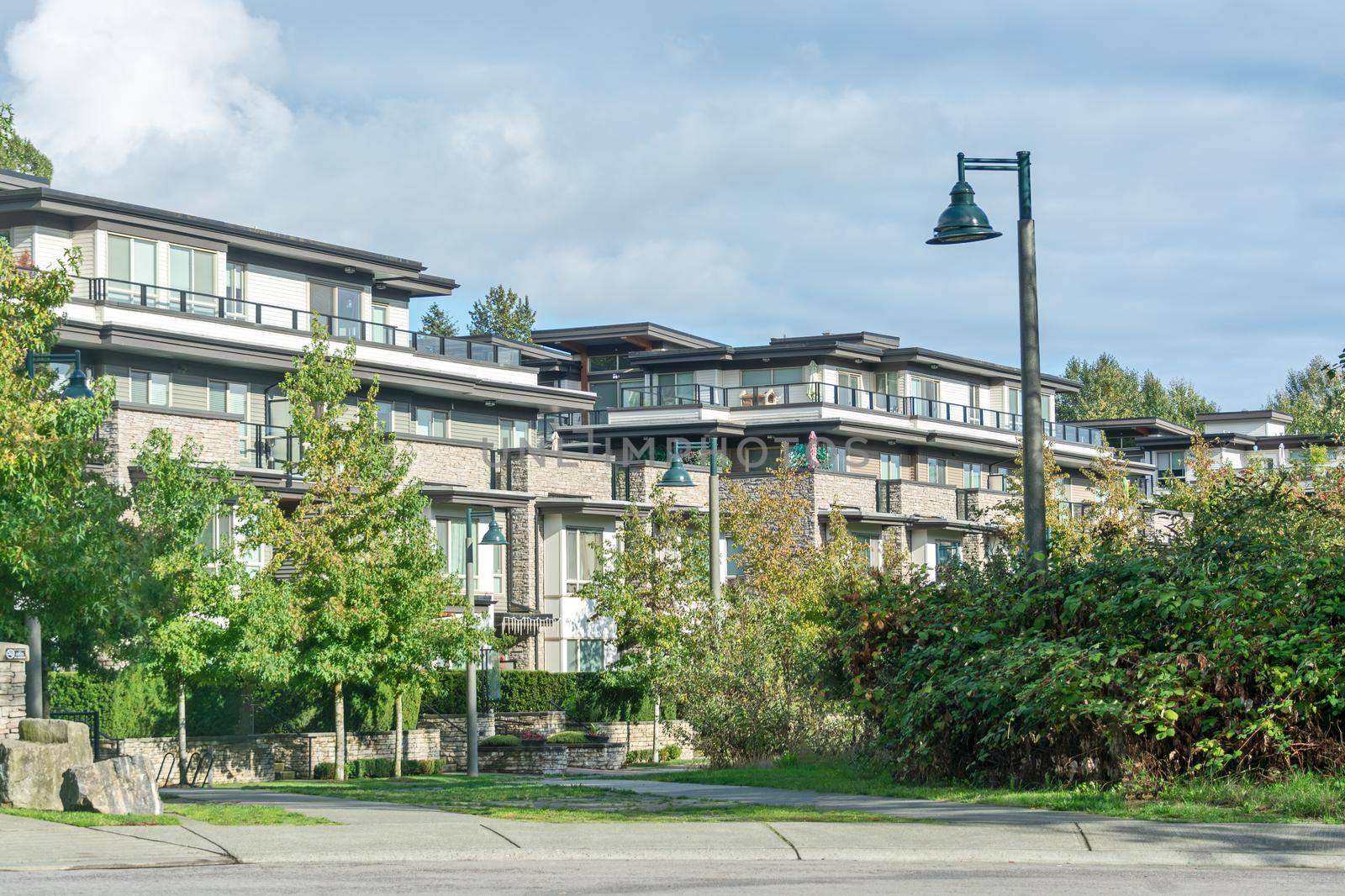 Residential apartment buildings on cloudy sky background.
