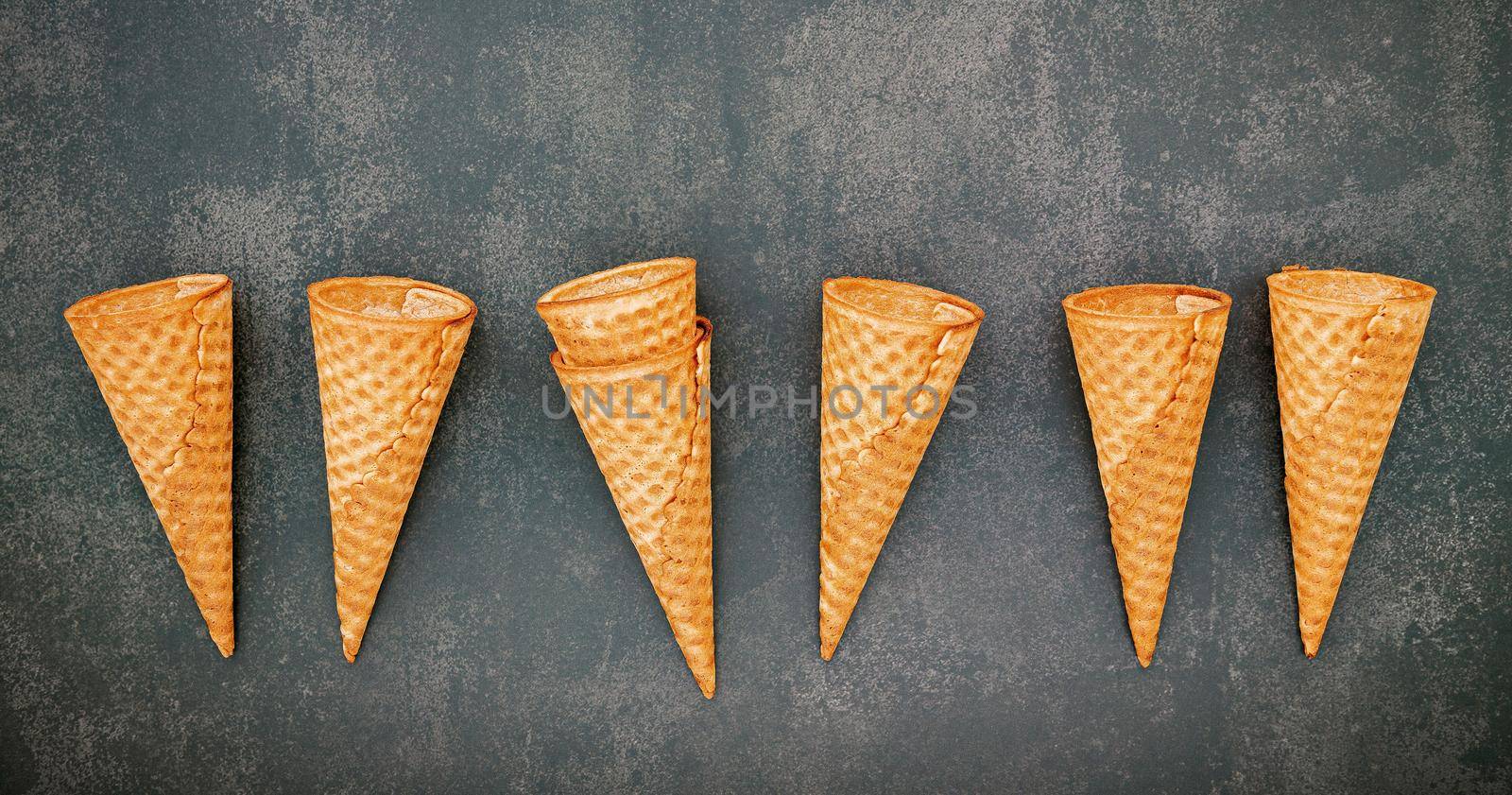 Flat lay ice cream cones collection on dark stone background . Blank crispy ice cream cone with copy space for sweets menu design. by kerdkanno