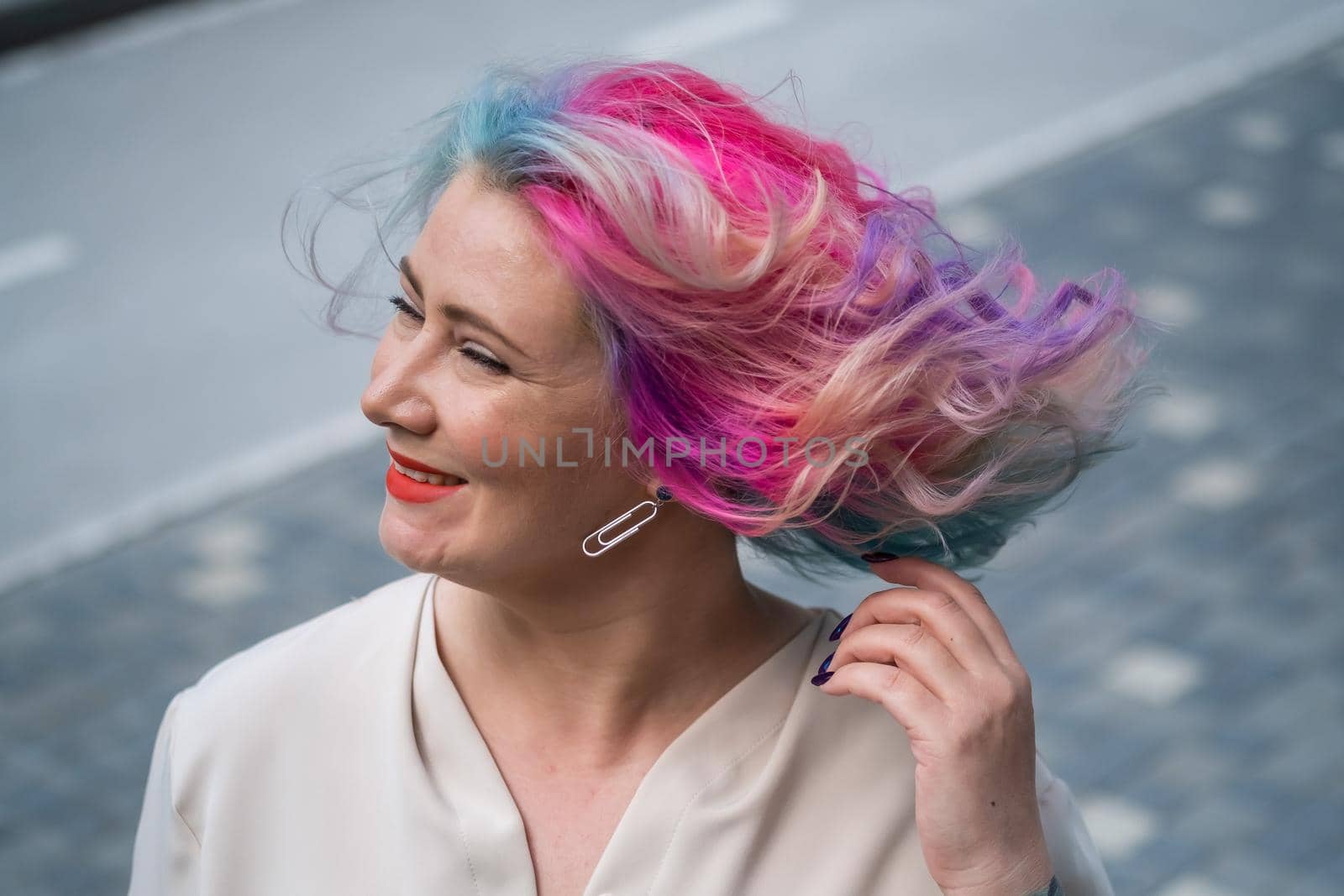 Close-up portrait of curly Caucasian woman with multi-colored hair. Model for hairstyles.