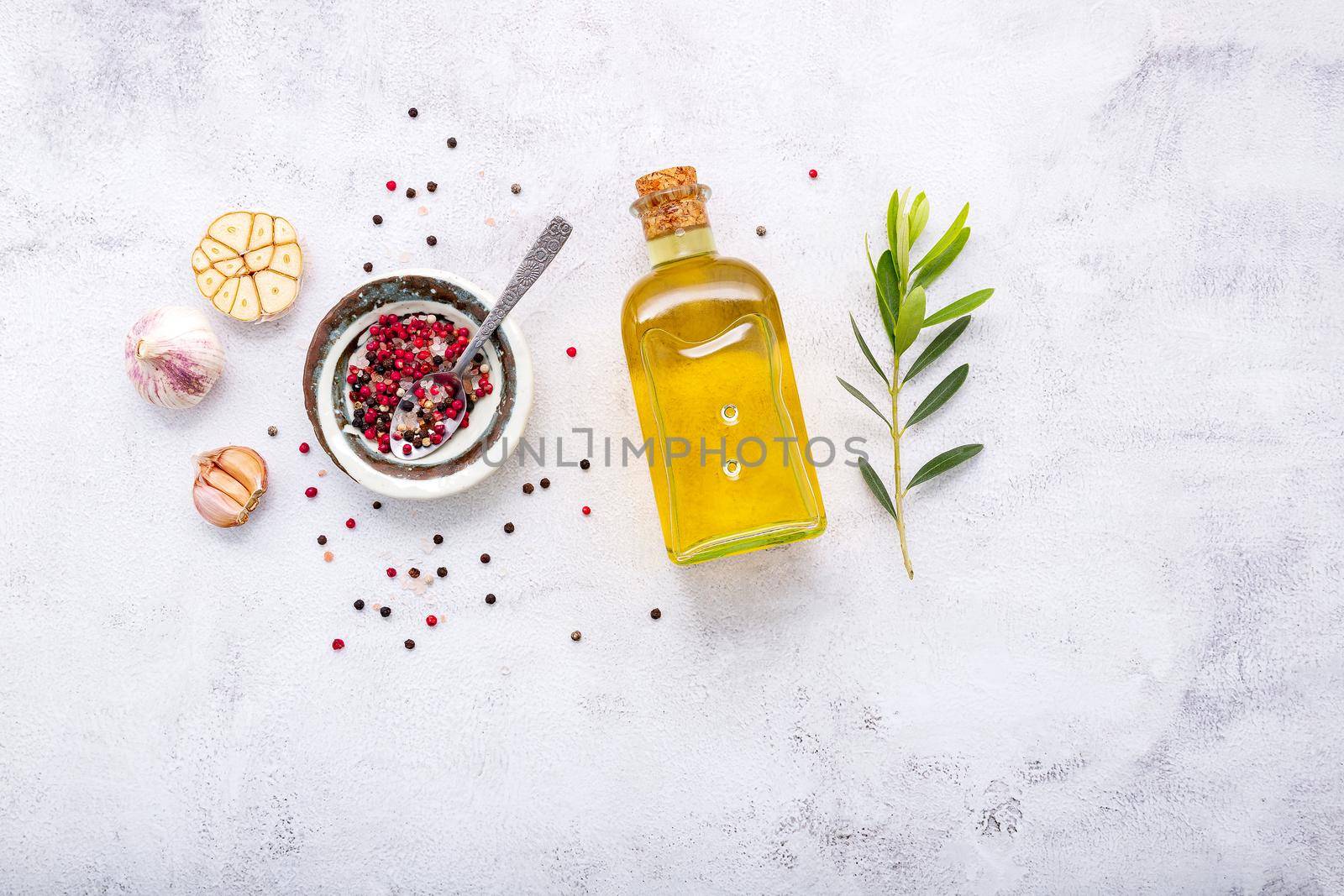 Glass bottle of olive oil and olive branch set up on white concrete background. by kerdkanno