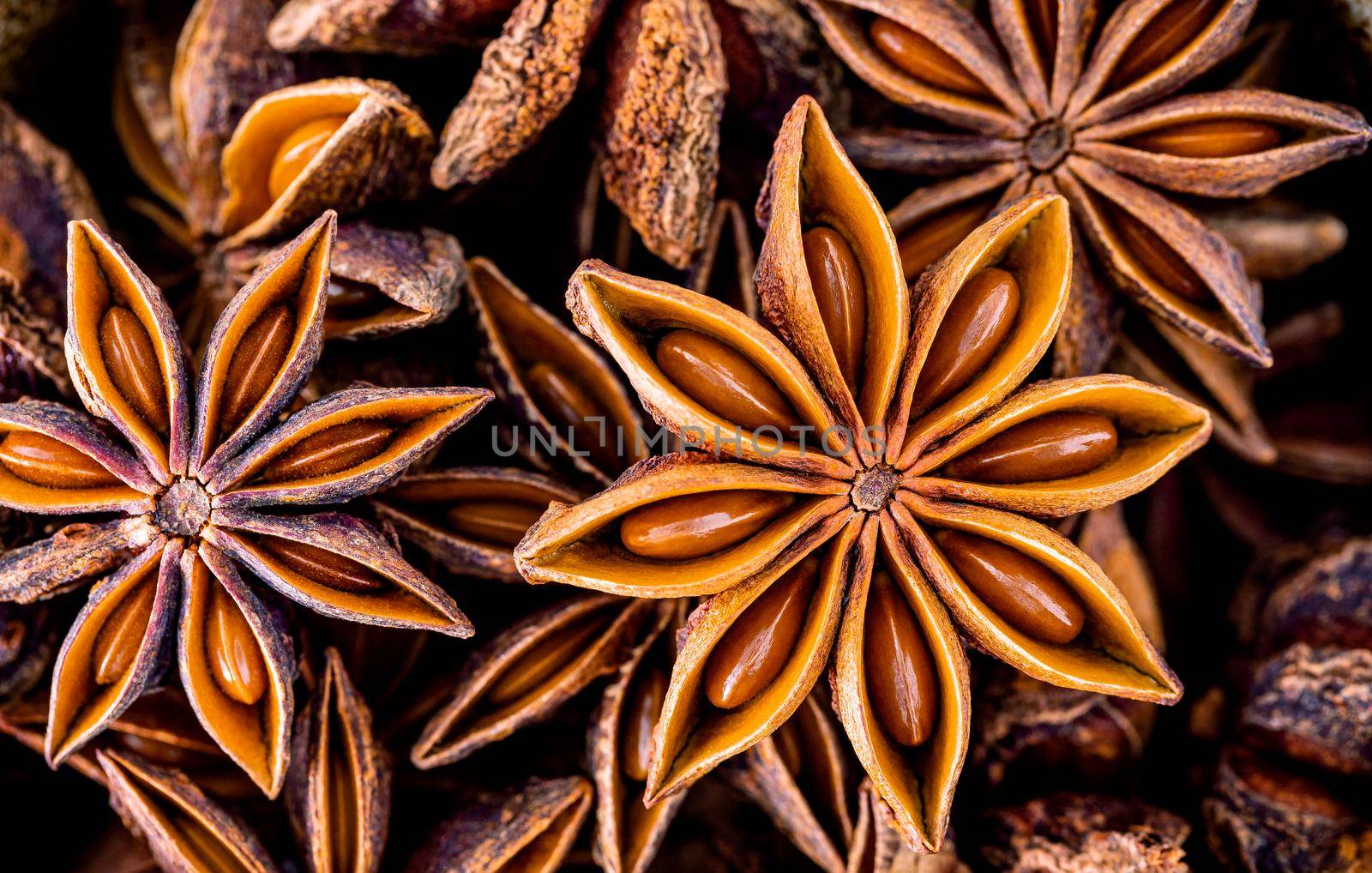 Chinese star anise close up background. Dried star anise spice fruits top view.
 by kerdkanno