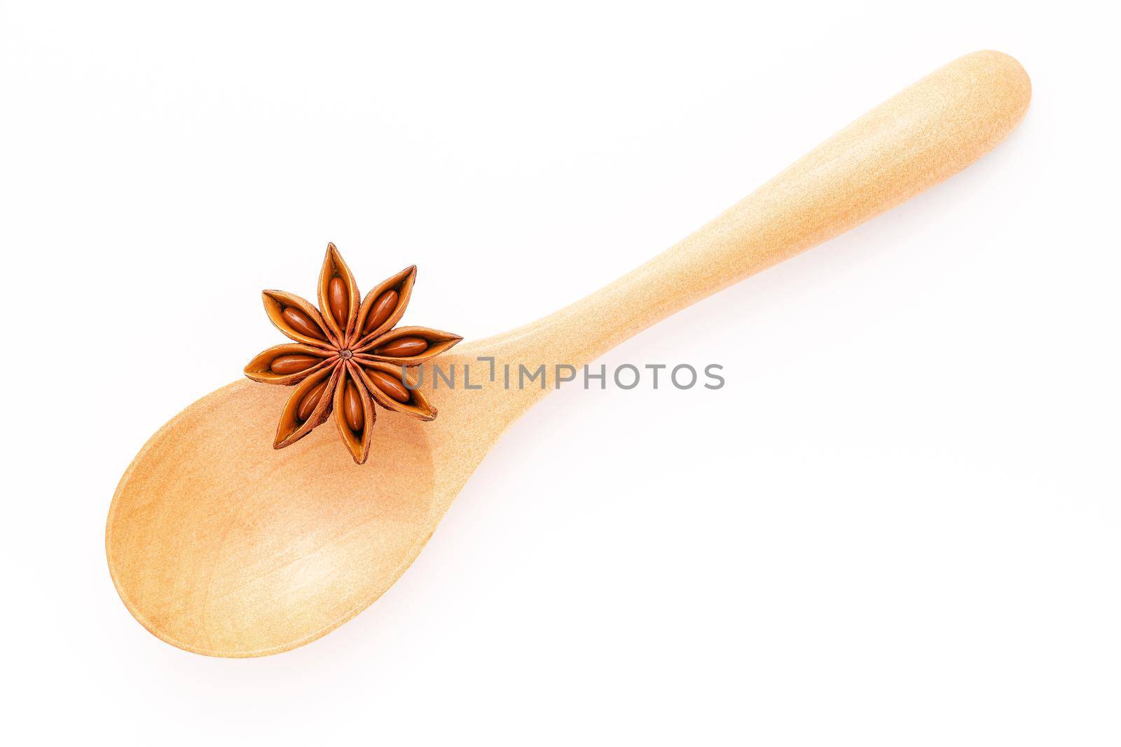 Close up chinese star anise in wooden spoon isolate on white background. Dried star anise spice fruits top view and copy space.