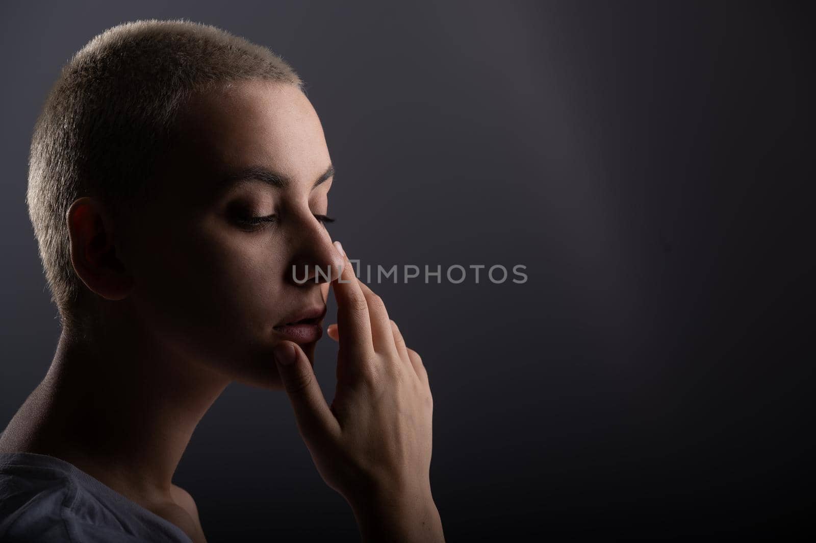 Portrait of pensive young woman with short hair on white background. Copy space.