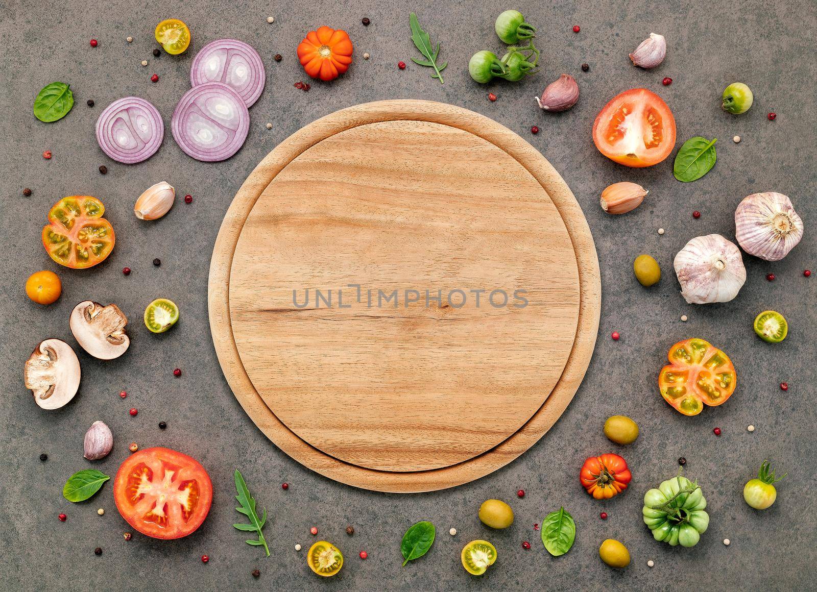 The ingredients for homemade pizza set up on dark stone background.