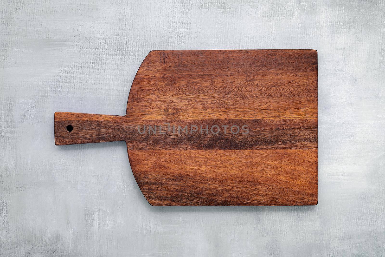 Empty vintage wooden cutting board set up on concrete background with copy space. by kerdkanno