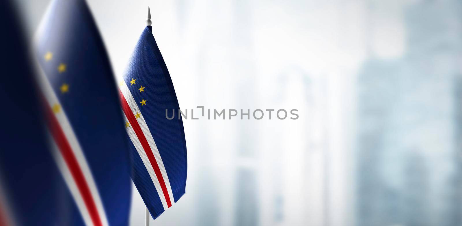 Small flags of Cape Verde on a blurry background of the city.