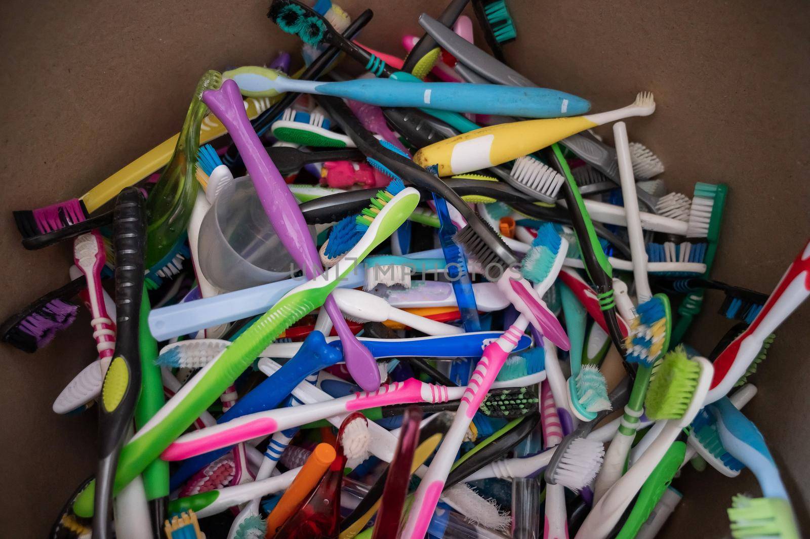 A close-up of many used plastic toothbrushes collected for recycling. by mrwed54