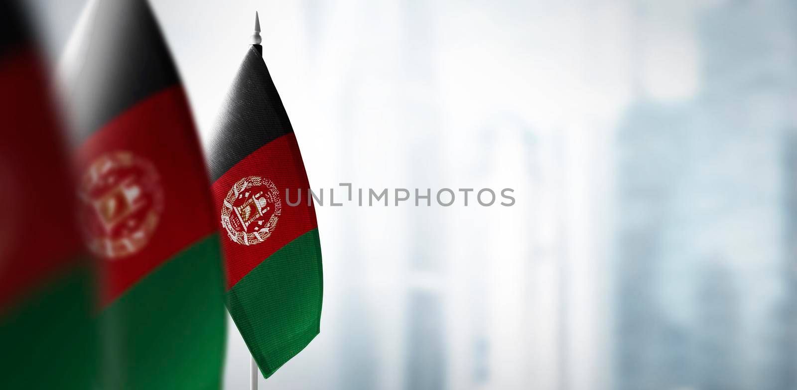 Small flags of Afghanistan on a blurry background of the city.