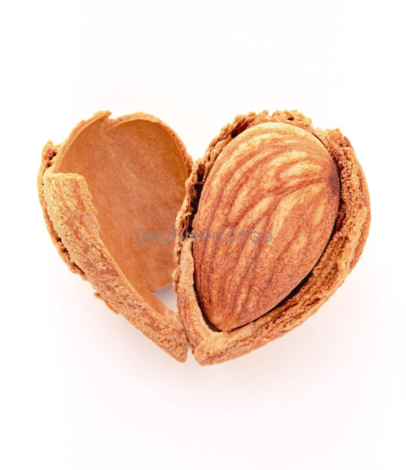 Close up almonds nut shell cracked in heart shape isolated on white background. Love healthy eating concept.