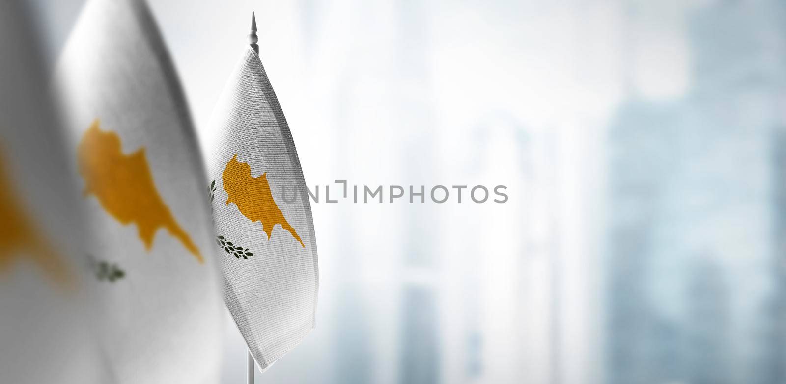 Small flags of Cyprus on a blurry background of the city by butenkow