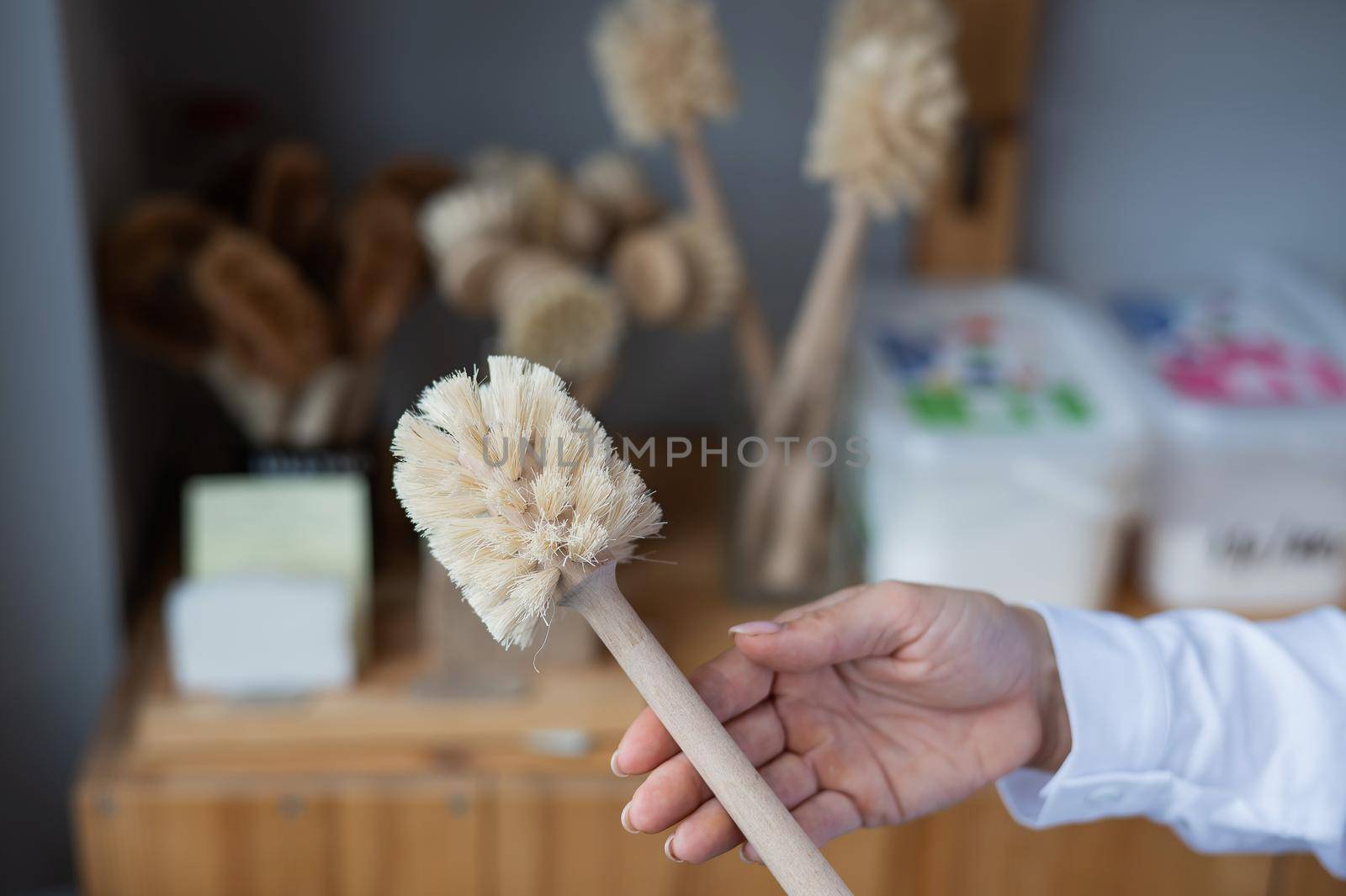 Woman holding eco friendly toilet brush. Natural products with zero waste.