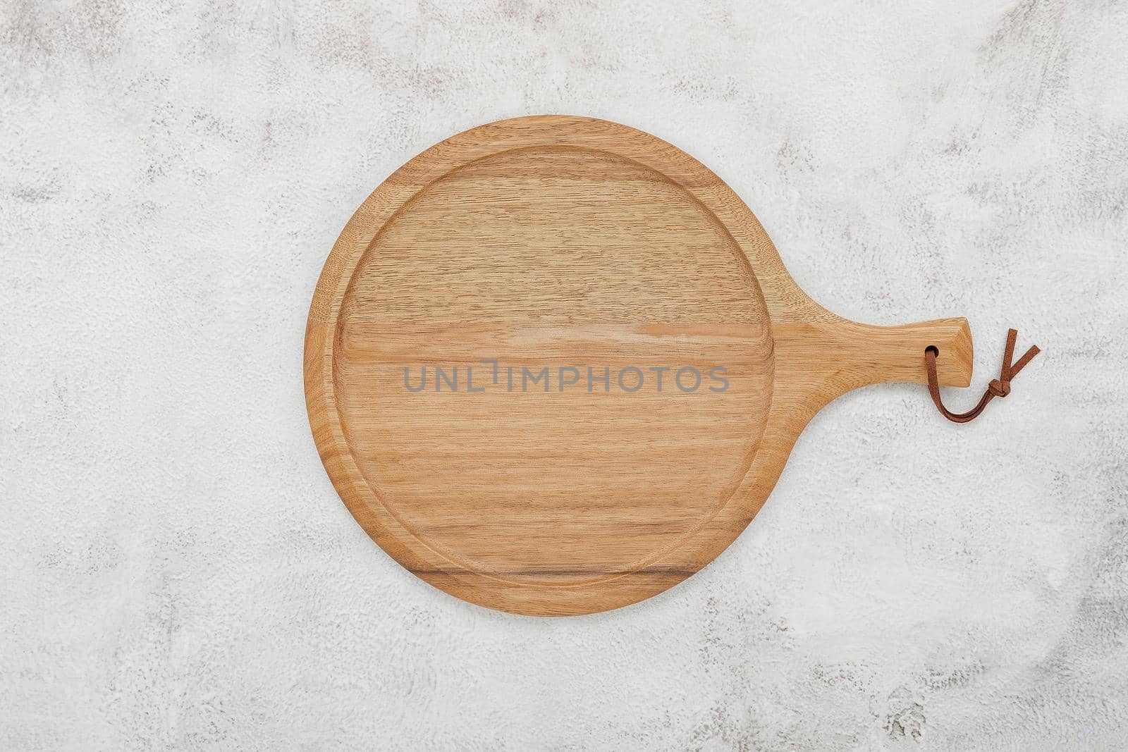 Empty wooden pizza platter set up on white concrete. Pizza tray on white concrete background flat lay and copy space.

